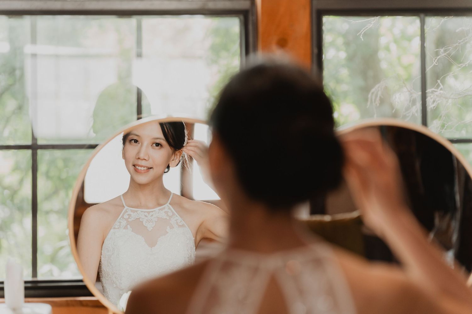 Bridal party smiling and laughing together during wedding preparations in a bright sunny room.