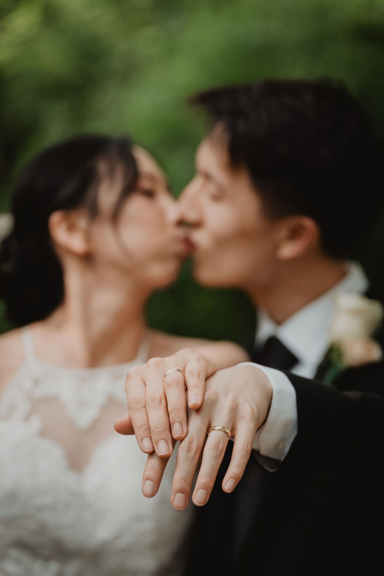 A romantic close-up shot of newlyweds displaying their wedding rings while sharing an intimate moment.