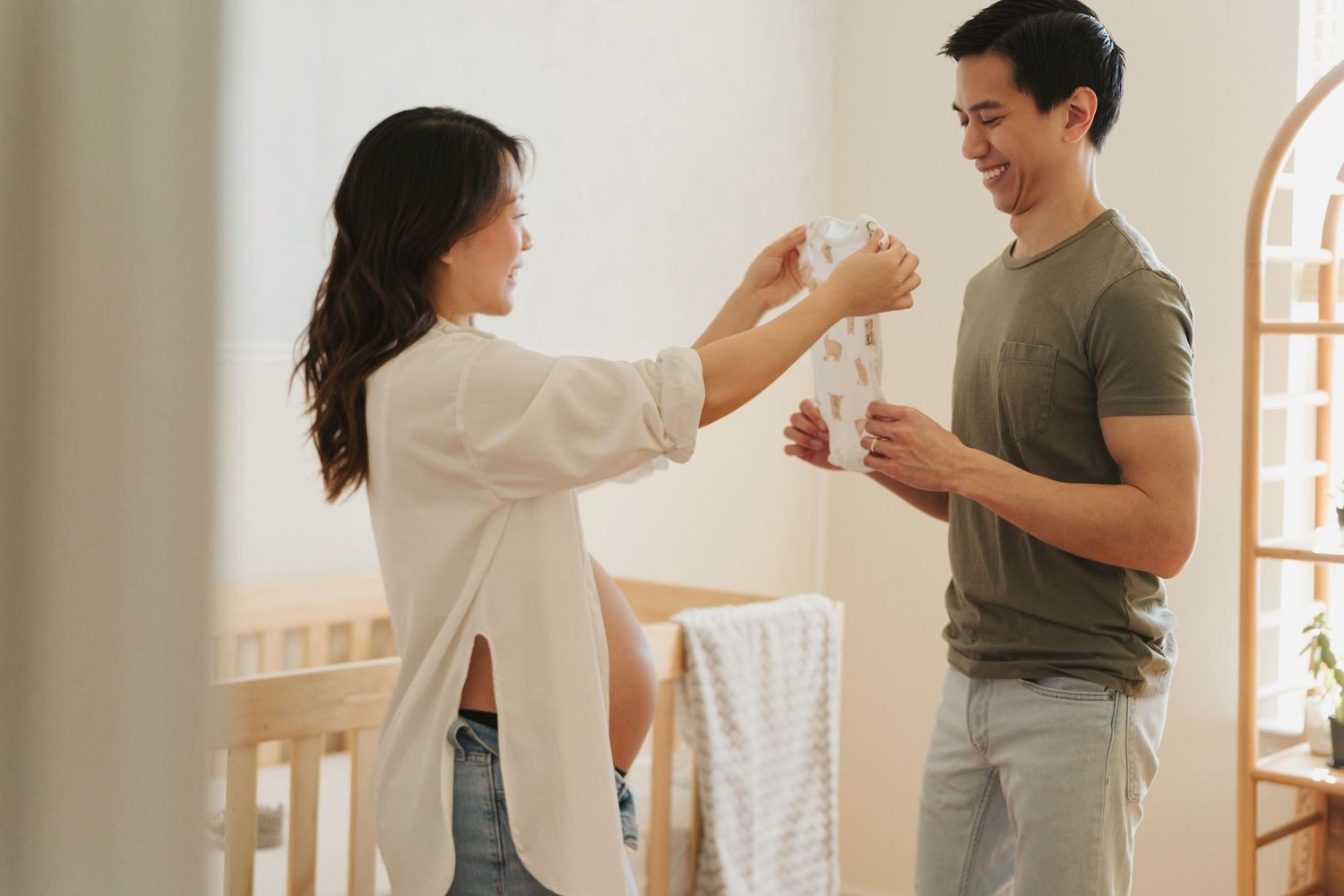 Two people dancing and laughing together in a bright minimalist living room setting.