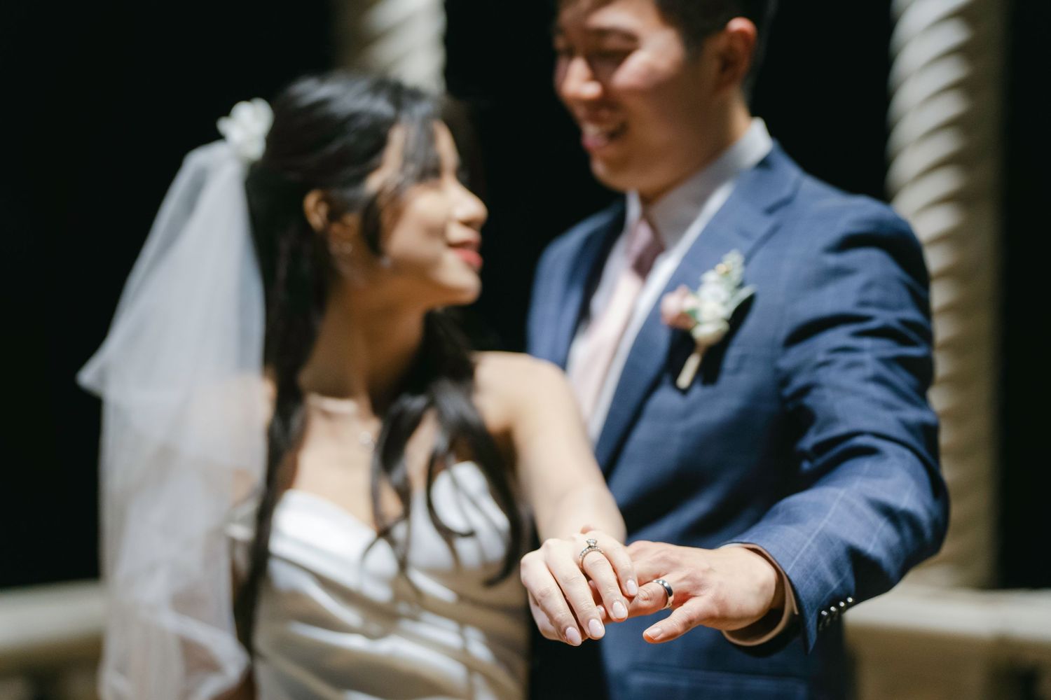 A close-up shot of newlyweds admiring their wedding rings during their ceremony.
