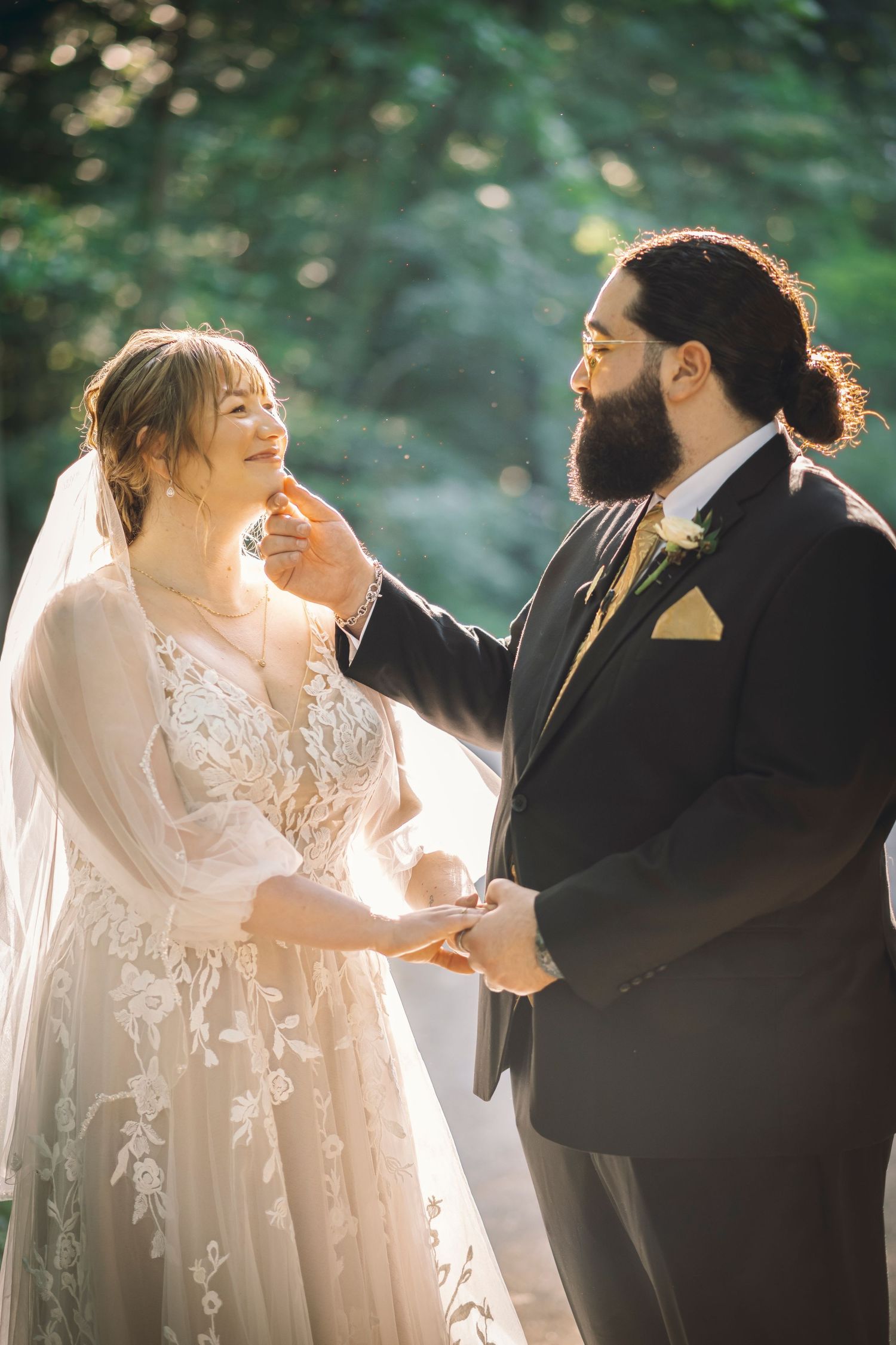 A tender moment between bride & groom after vows as the sunshine pours through the forest canopy; moments like these are timeless.