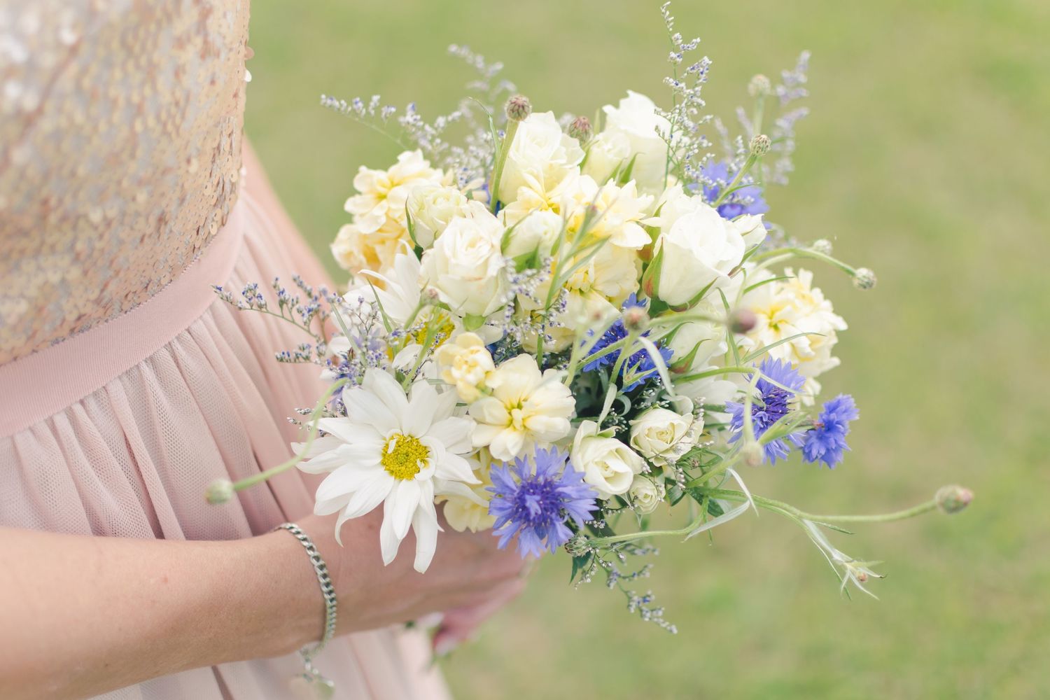 Bride holds beautiful ivory and lilac bouquet during her bridal portraits.