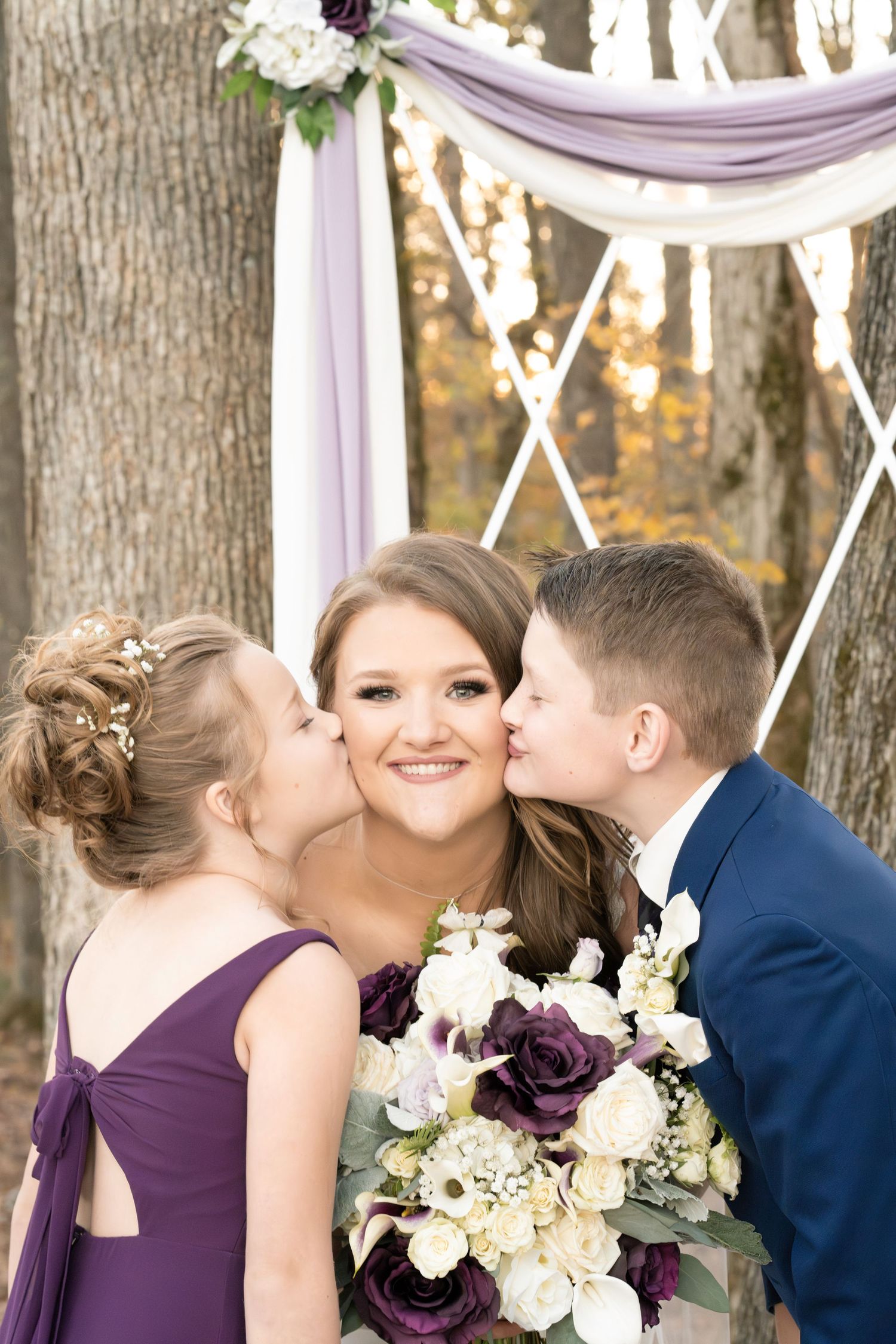Children kiss the bride on the cheek after ceremony.
