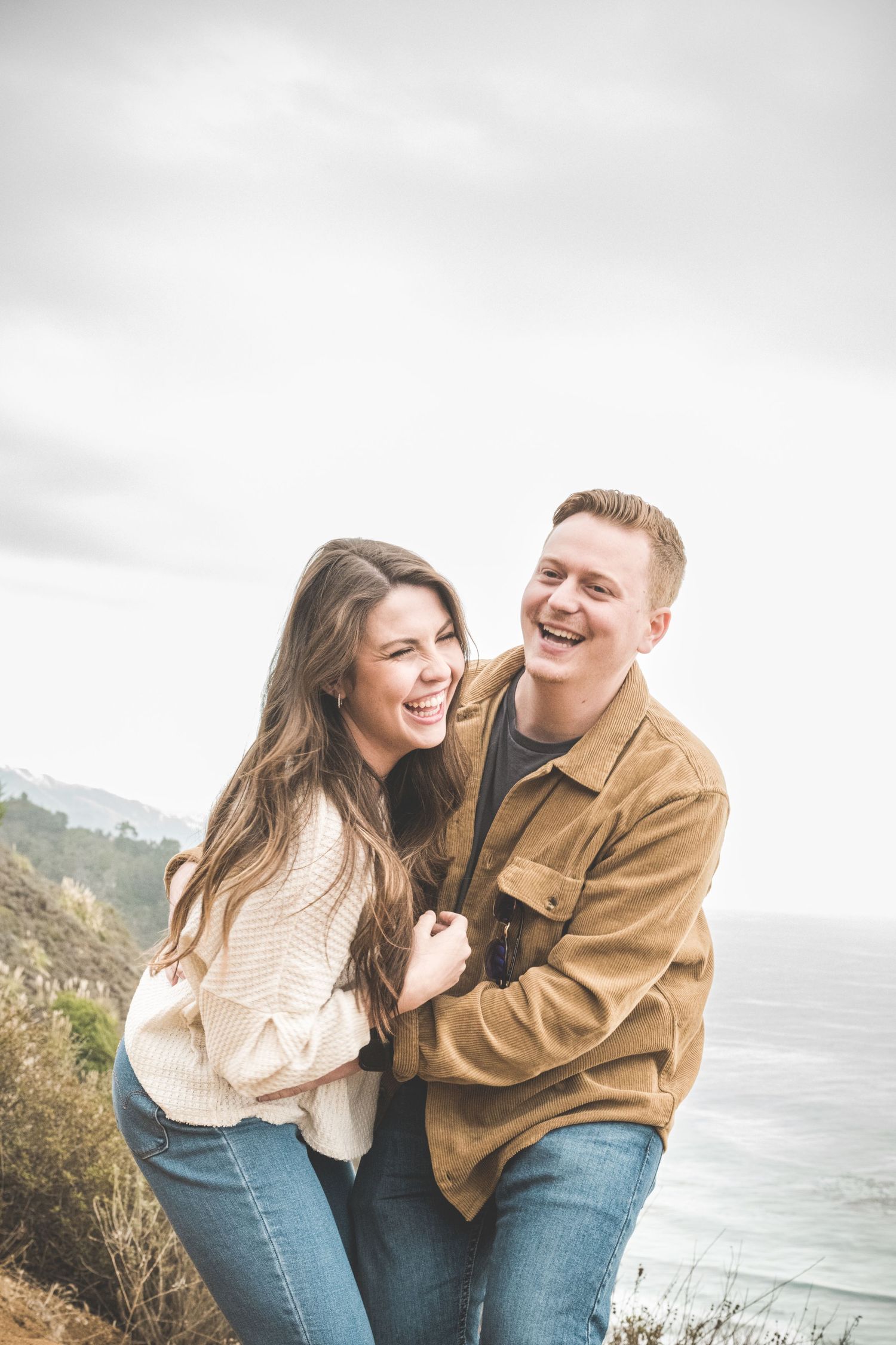 Couple at Big Sur, CA as Robinson Photography captures the love and laughter on the Pacific Coast. Connect today to experience.