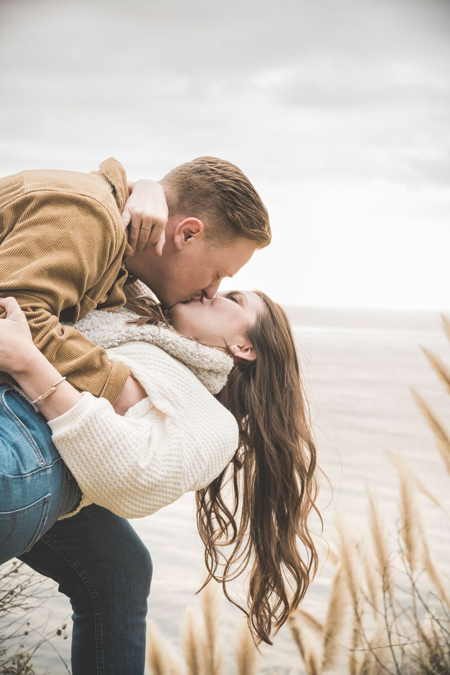 Couple at Big Sur, CA dip and kiss on the Pacific Coast. Connect with Robinson Photography today to experience your own custom session.