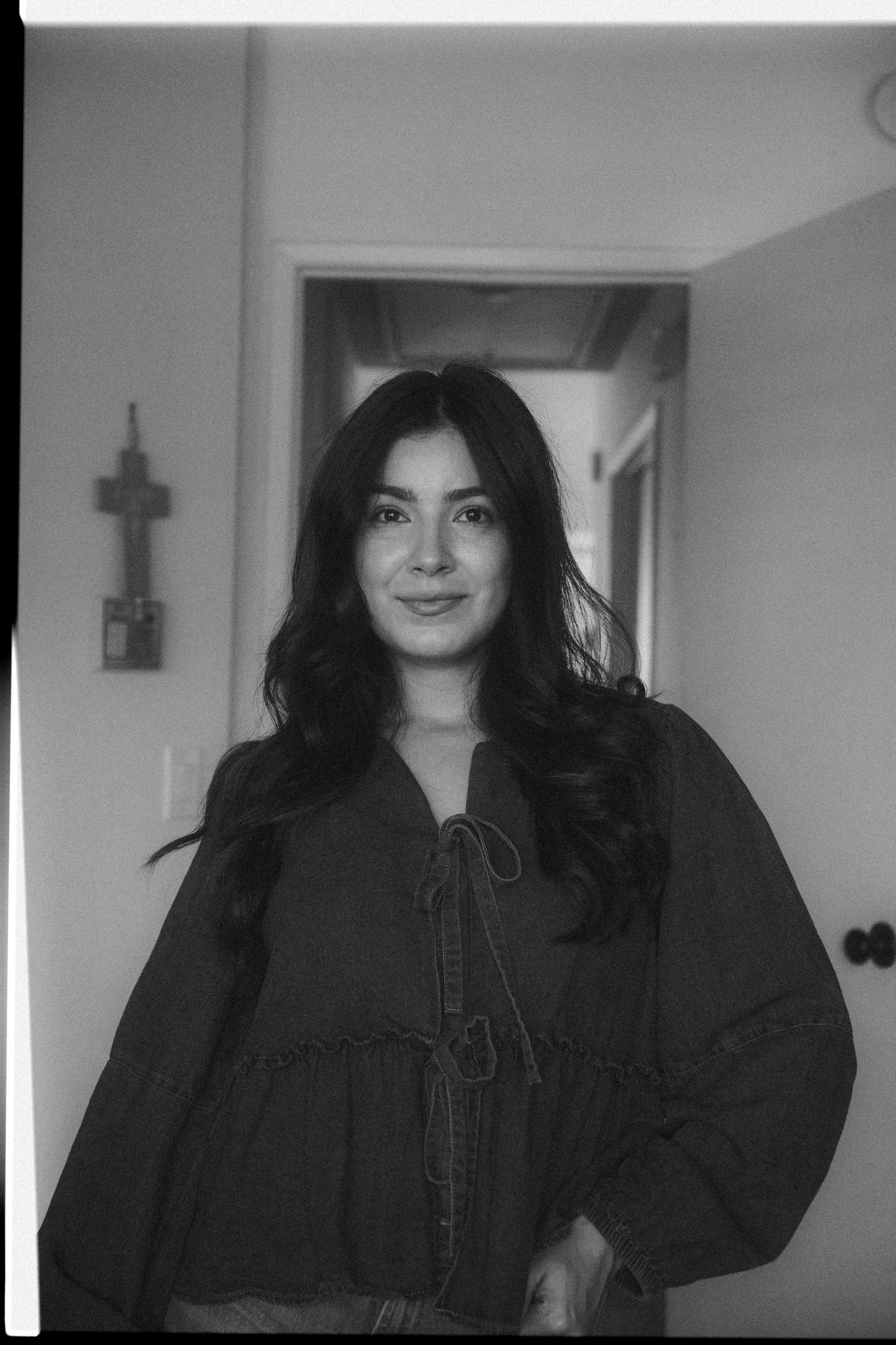 A series of black and white photos showing someone in a dark dress with long hair posing against a light background.