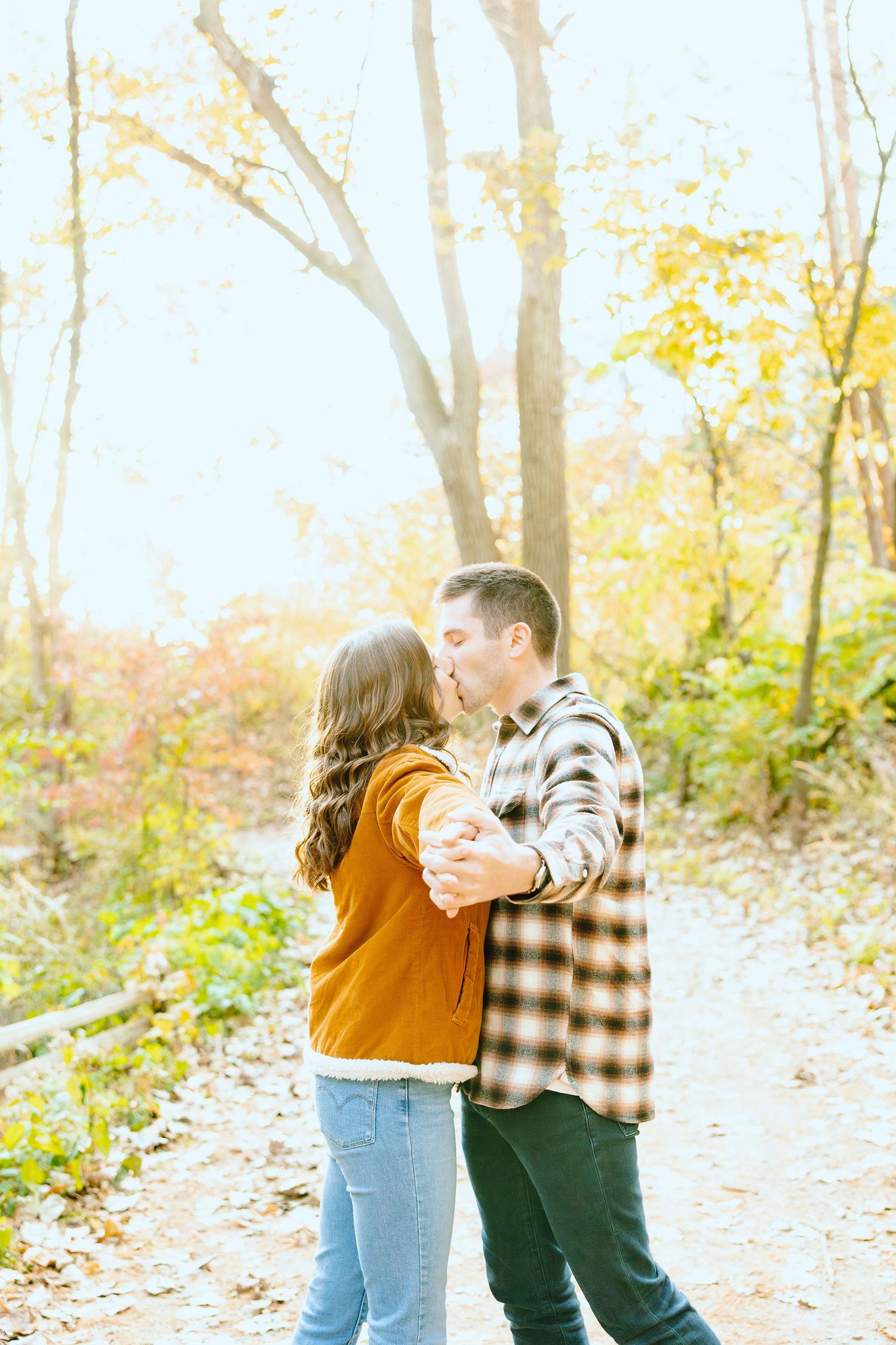 Engaged couple embracing in forest at Nichols Arboretum fall engagement session in Ann Arbor, MI