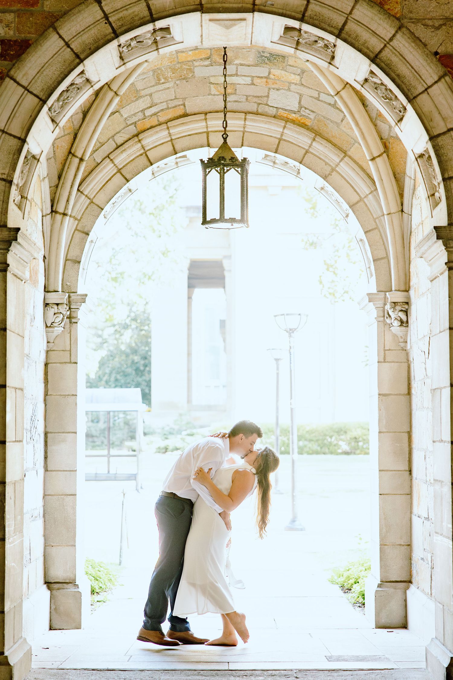 Engaged couple dipping and kissing at the UM Law Quad engagement session in Ann Arbor, MI