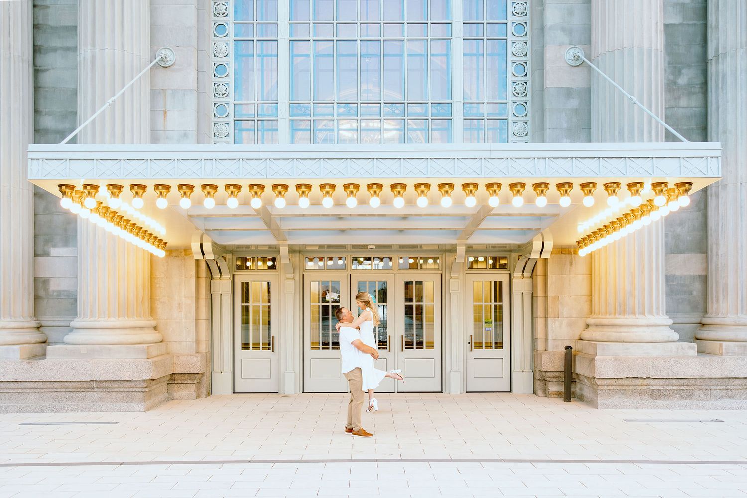 Man lifting woman at Michigan Central Station summer engagement session in Detroit, MI