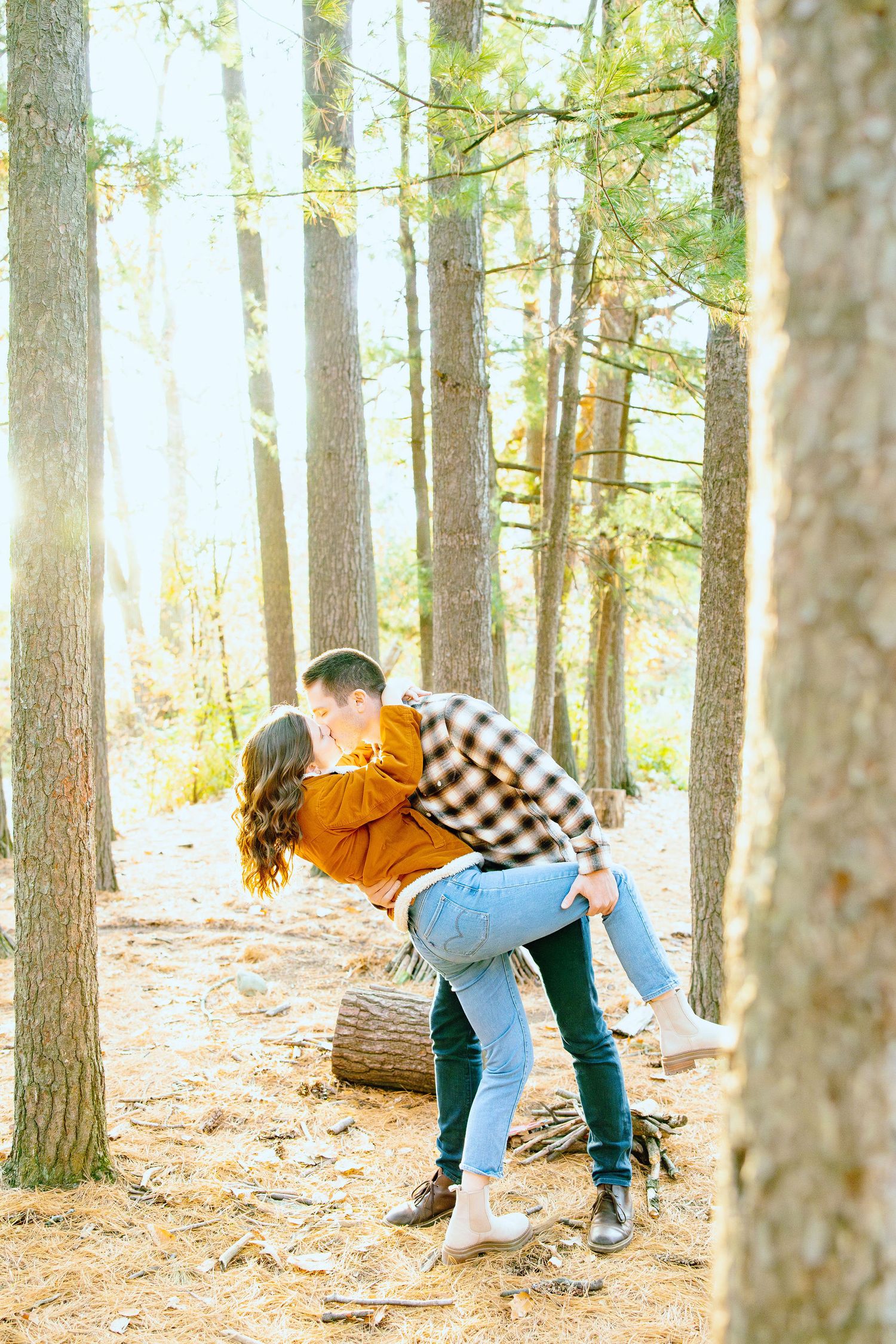 Engaged couple dipping in forest at Nichols Arboretum fall engagement session in Ann Arbor, MI