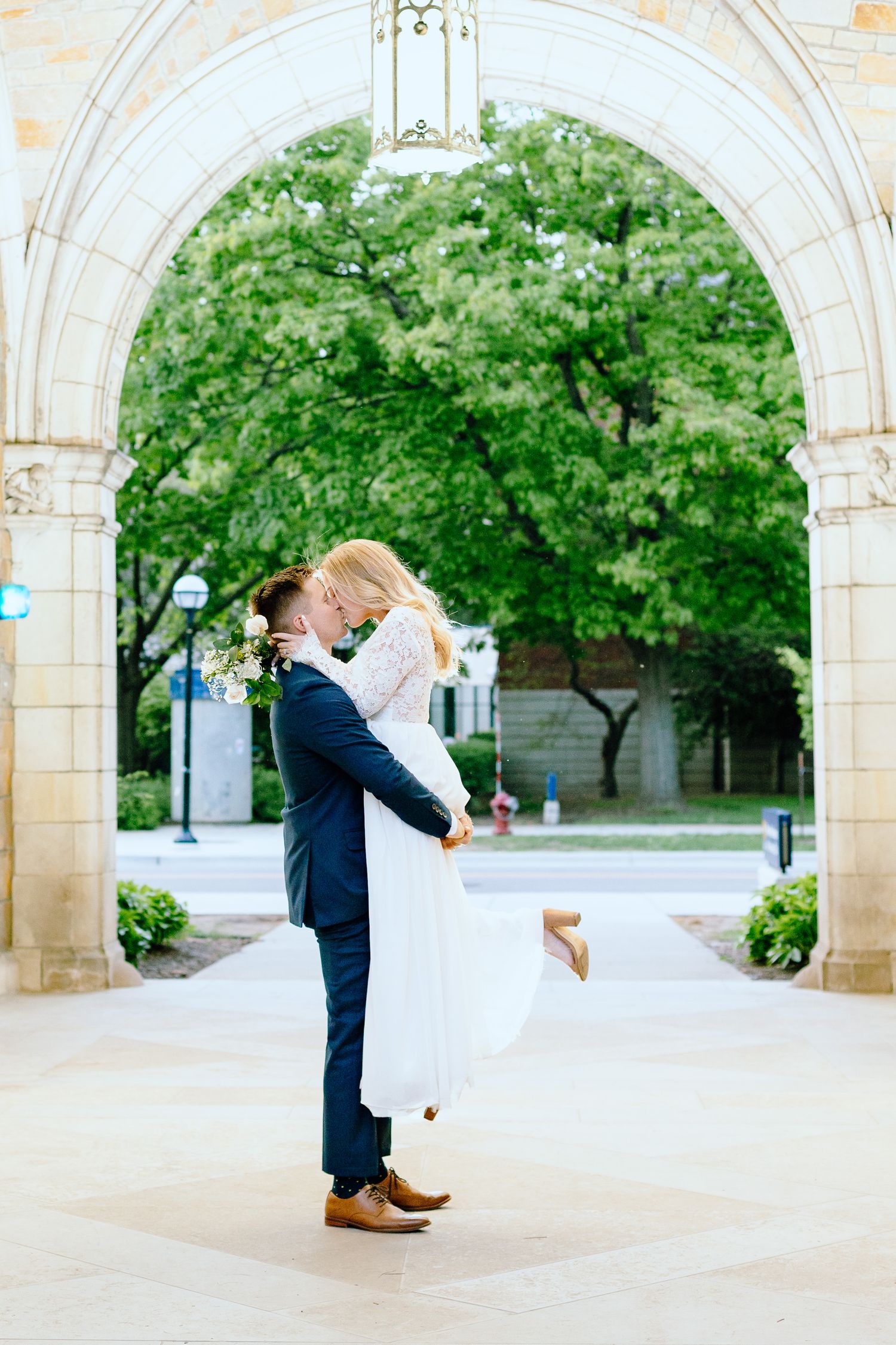 Bride and groom embrace under archway at Law Quadrangle, Ann Arbor, MI elopement