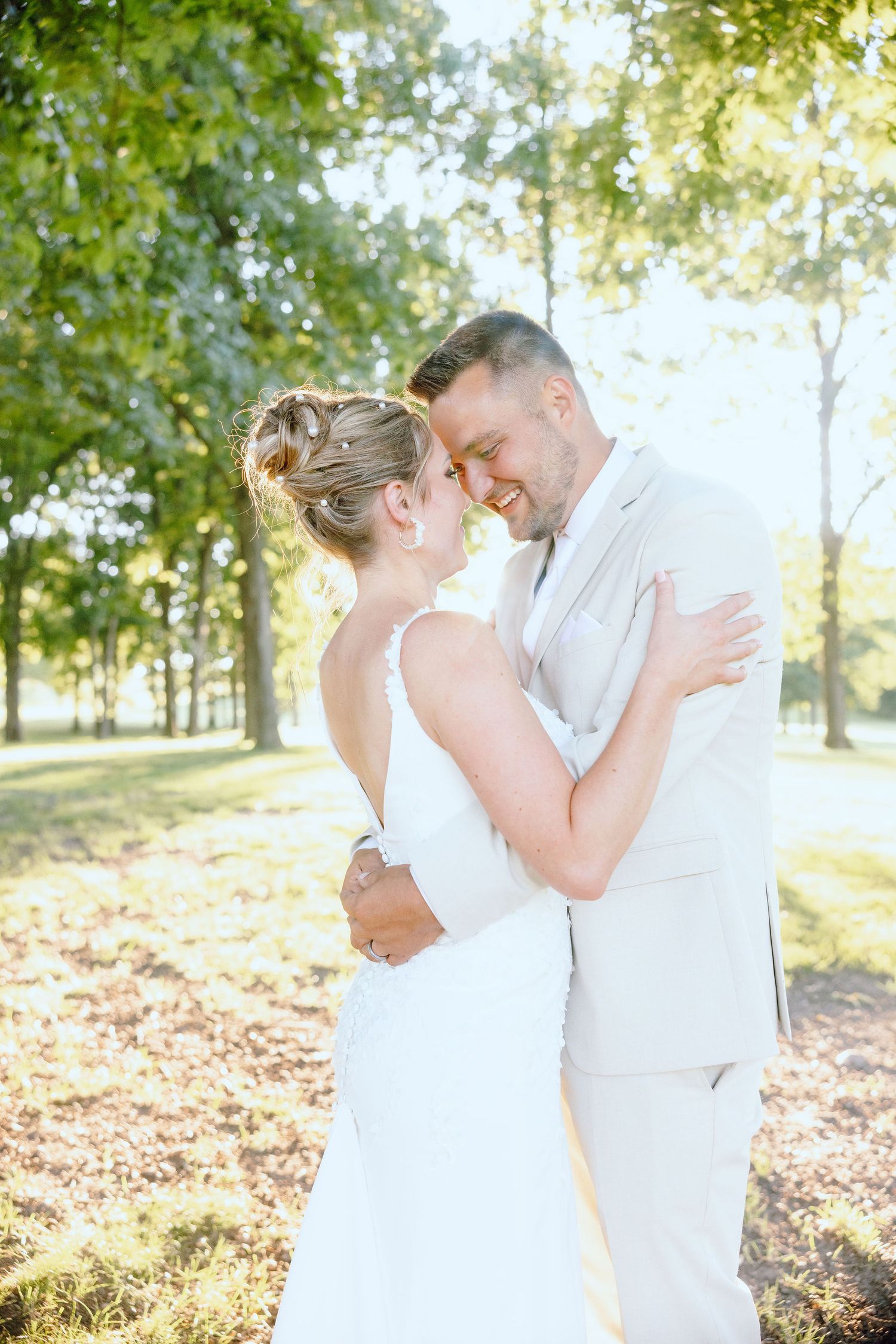 Married couple embracing during golden hour at Lapeer Country Club forest wedding in Michigan
