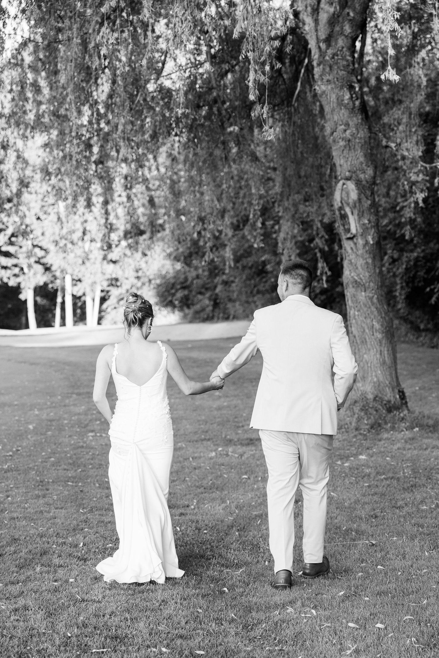 Married couple walking during golden hour at Lapeer Country Club wedding in Michigan
