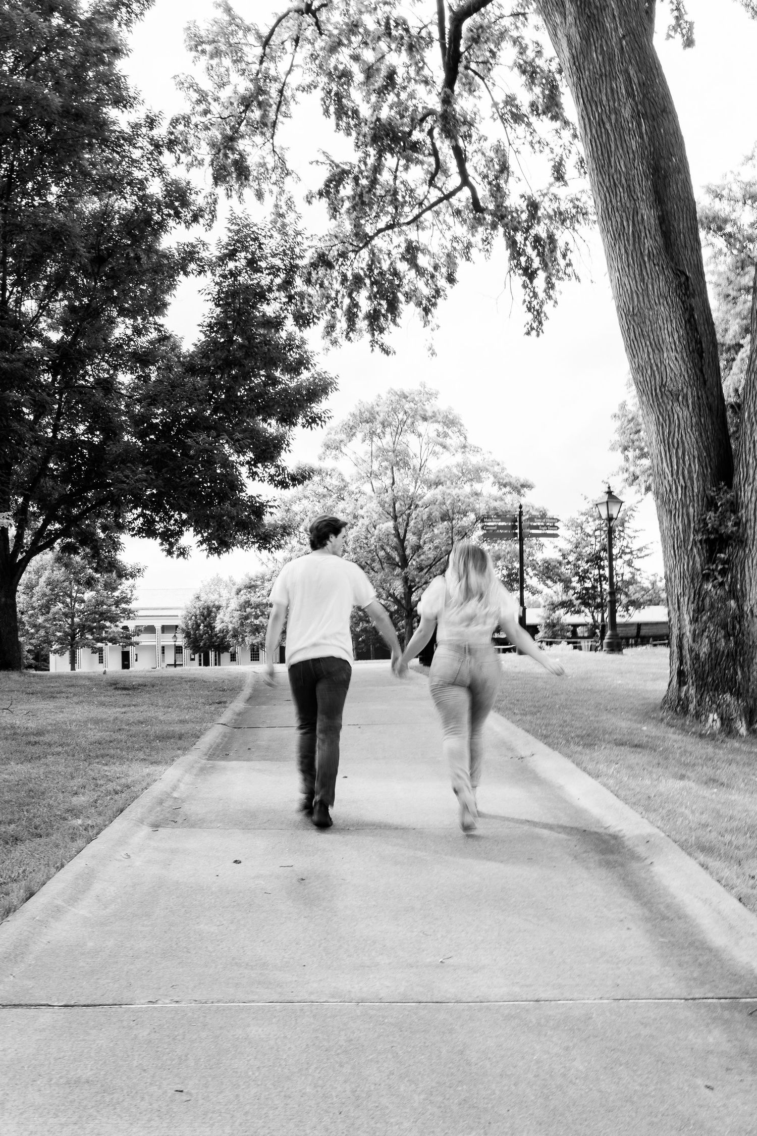 Engaged couple running at Greenfield Village in Dearborn, MI