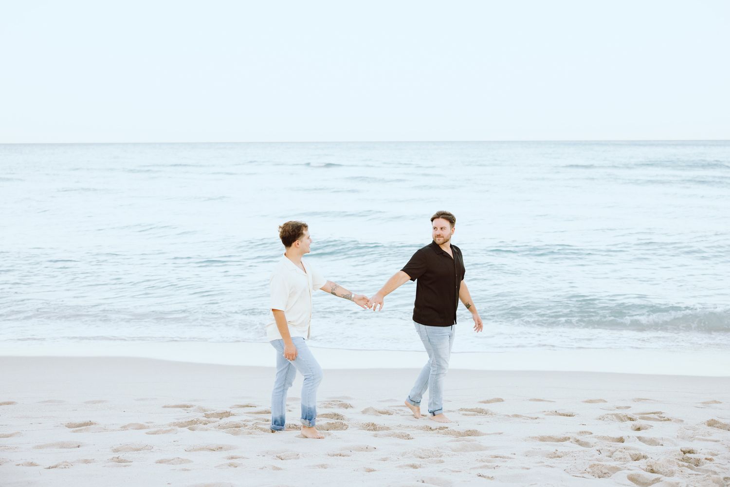 LGBTQ+ couple walking and holding hands on North Miami Beach in Florida