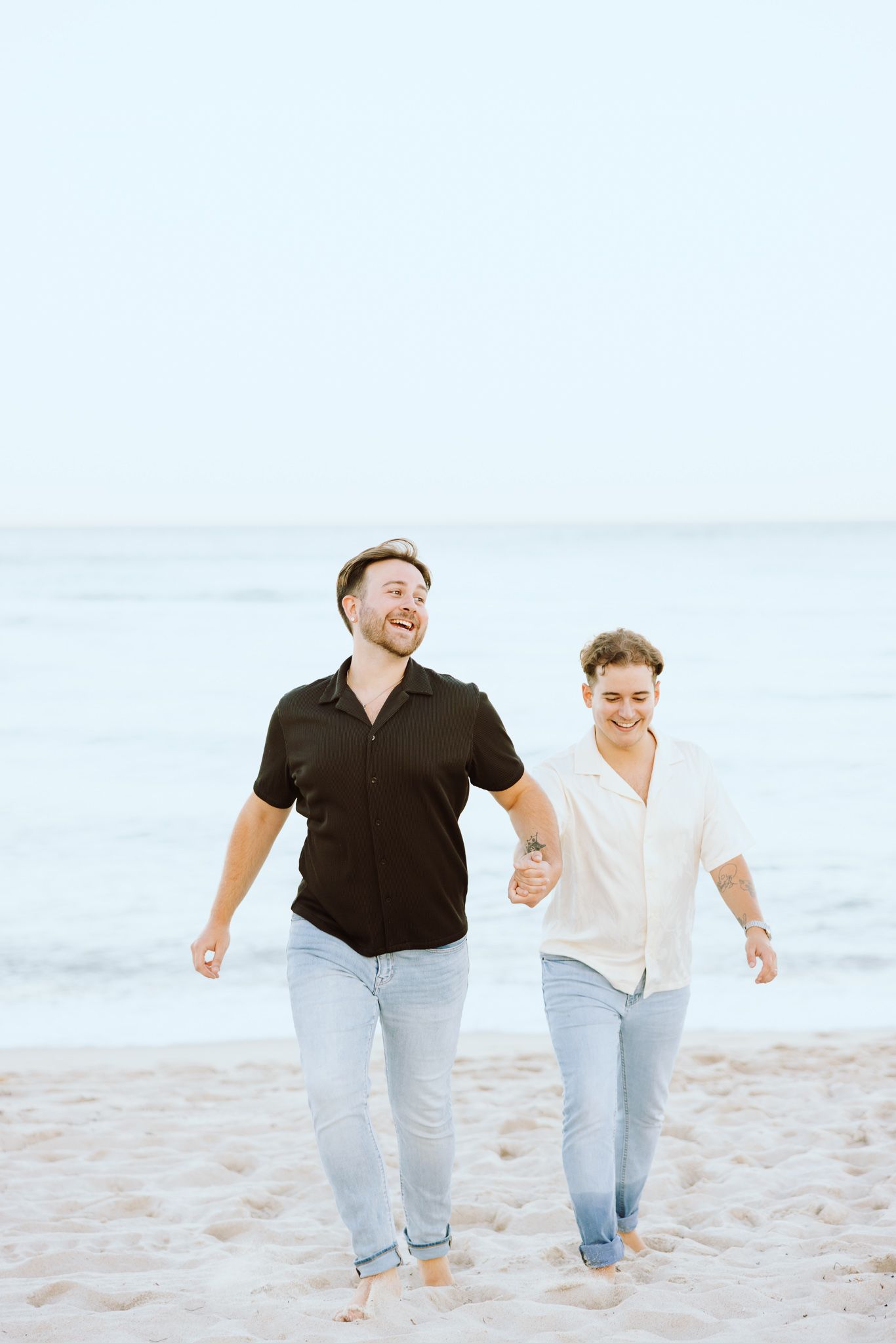 LGBTQ+ couple walking and holding hands on North Miami Beach in Florida