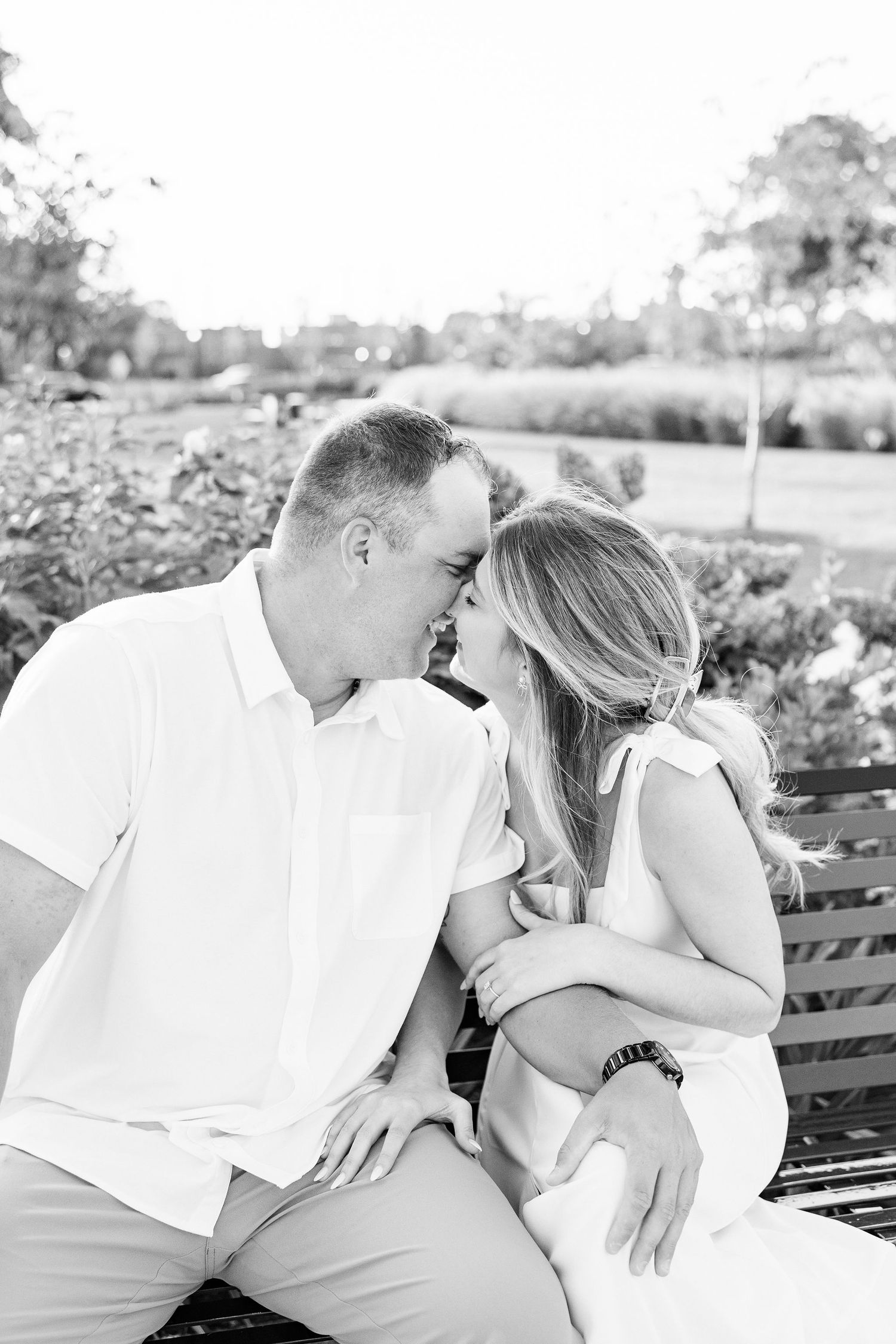 Engaged couple kissing on bench at Michigan Central Station in Detroit, MI