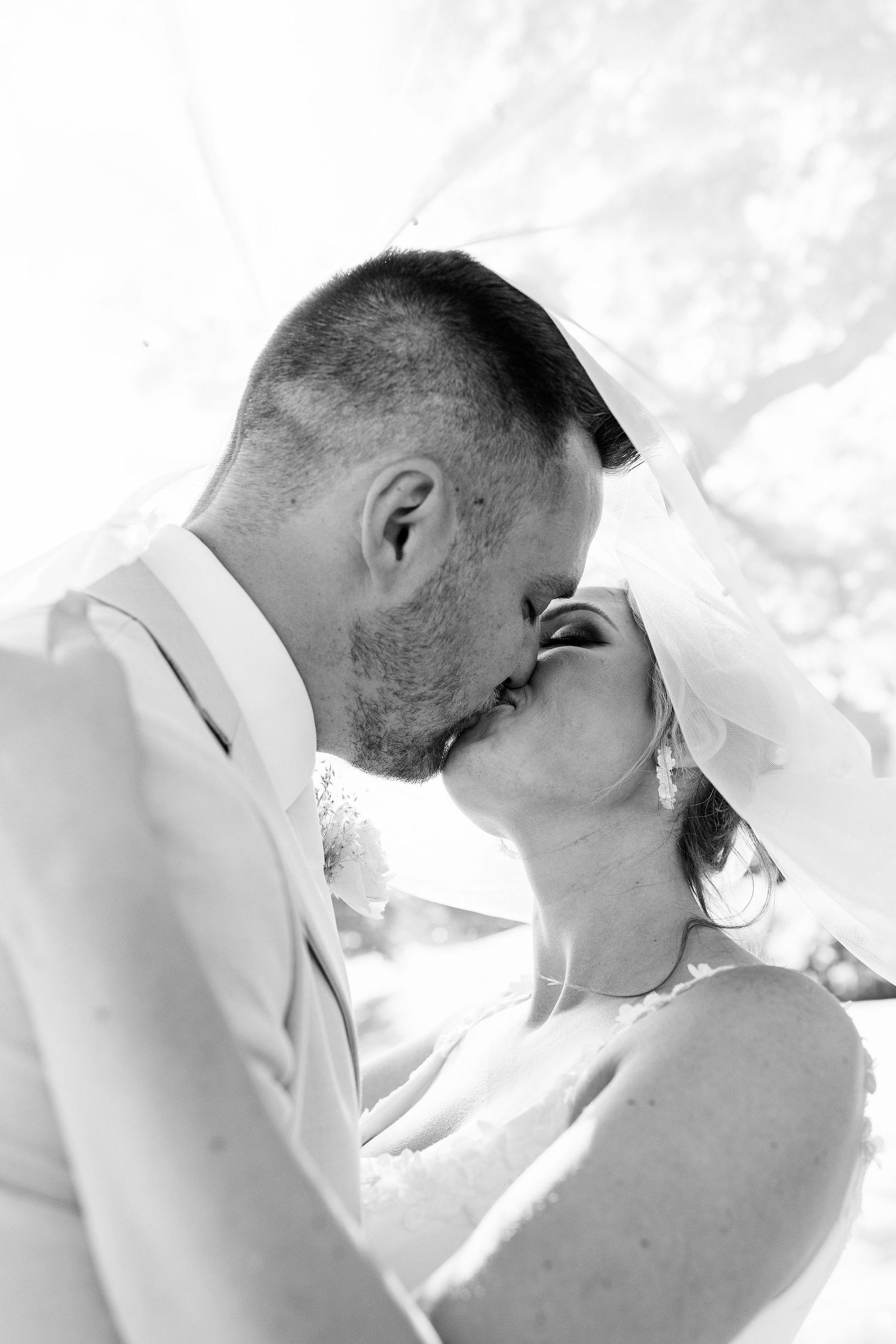 Married couple kissing under veil at Lapeer Country Club wedding in Michigan