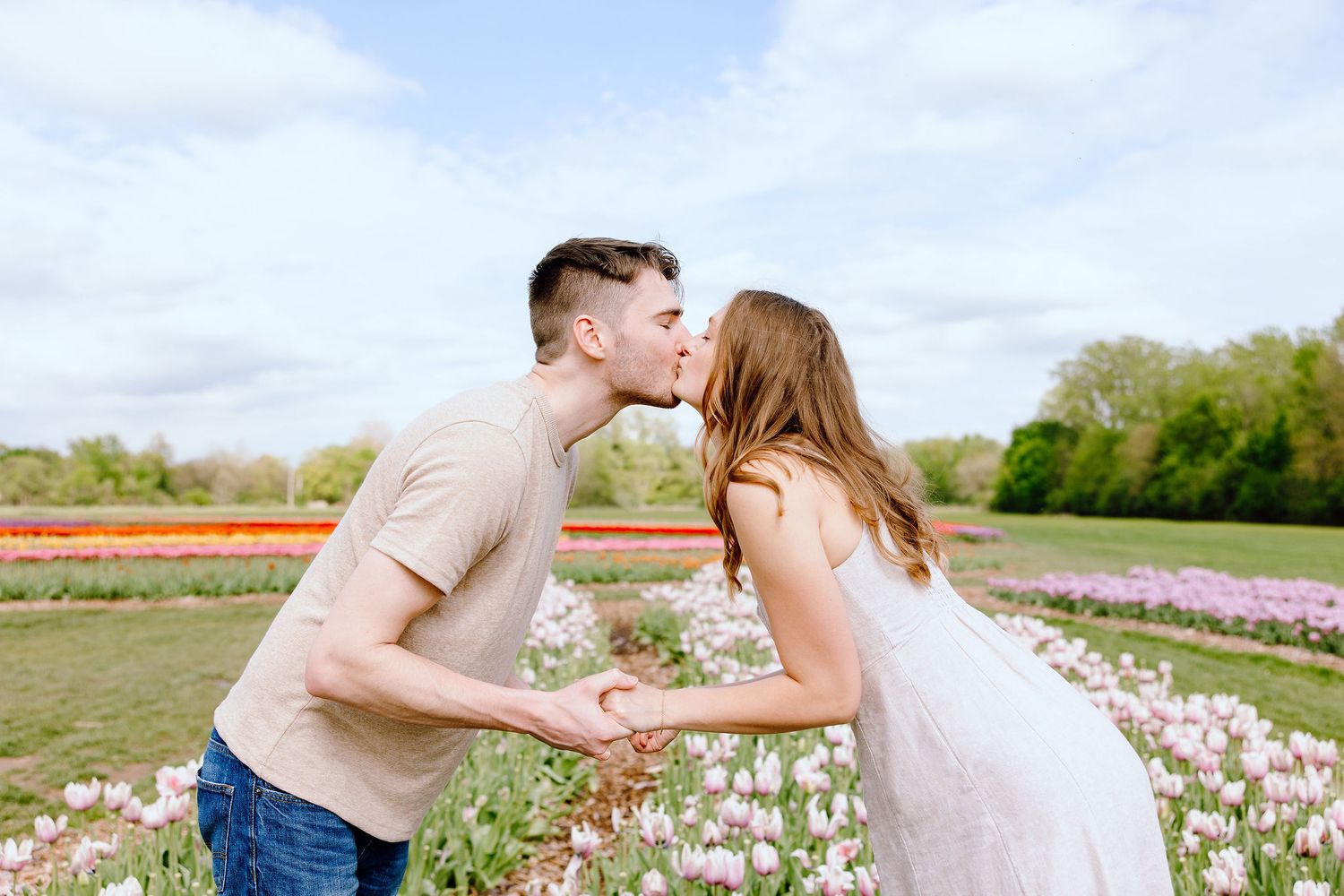 Engaged couple kissing at DeBuck's tulip field spring engagement session in Belleville, MI