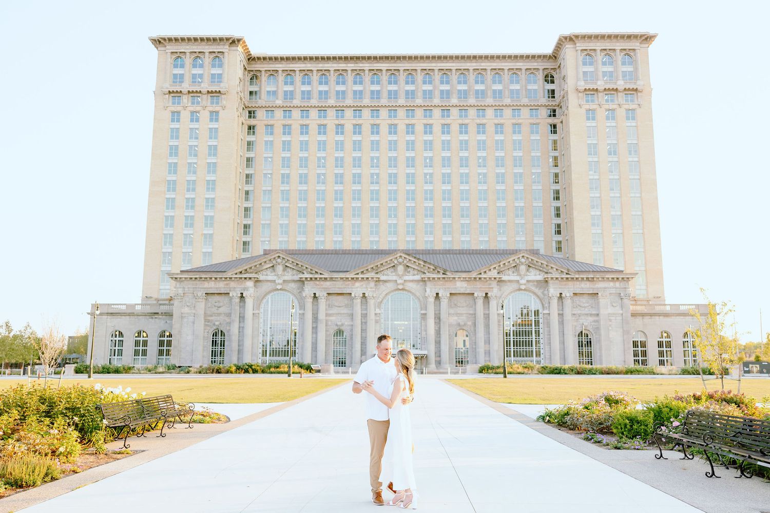 Engaged couple embracing at Michigan Central Station summer engagement session in Detroit, MI