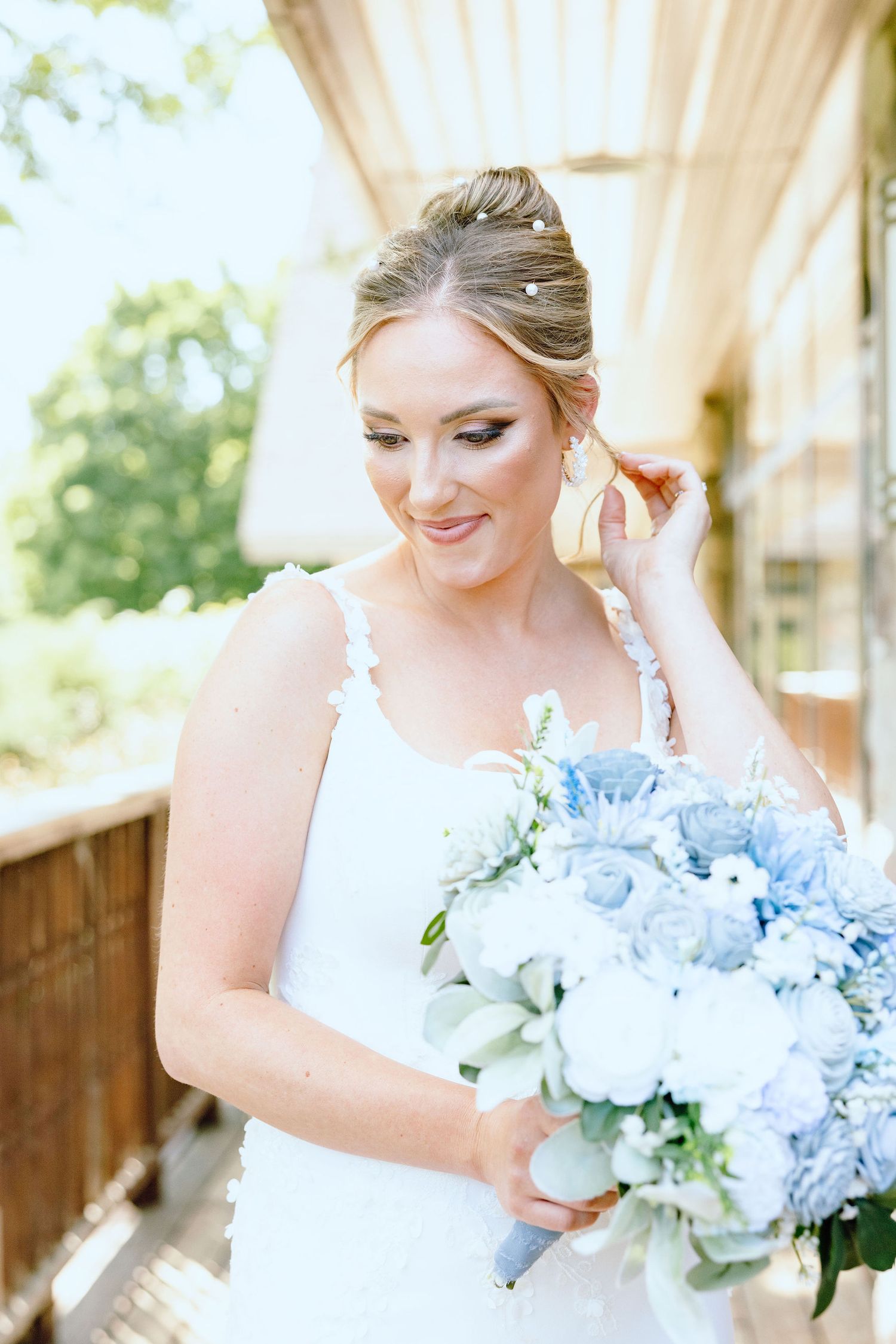 Bride holding bouquet and fixing hair at Lapeer Country Club wedding in Michigan