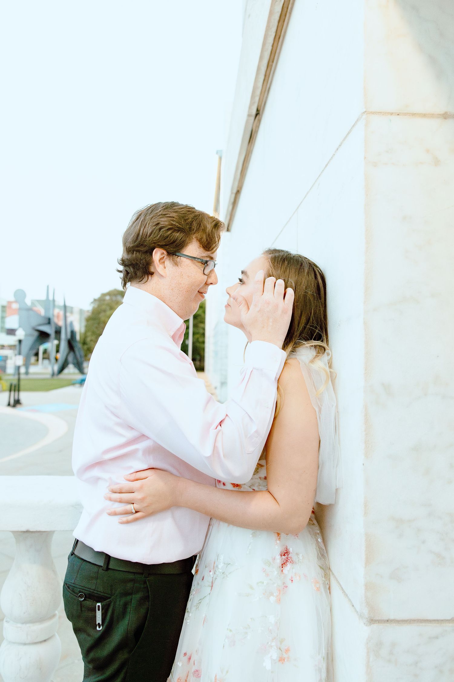 Engaged couple leaning against wall at Belle Isle summer engagement session in Detroit, MI