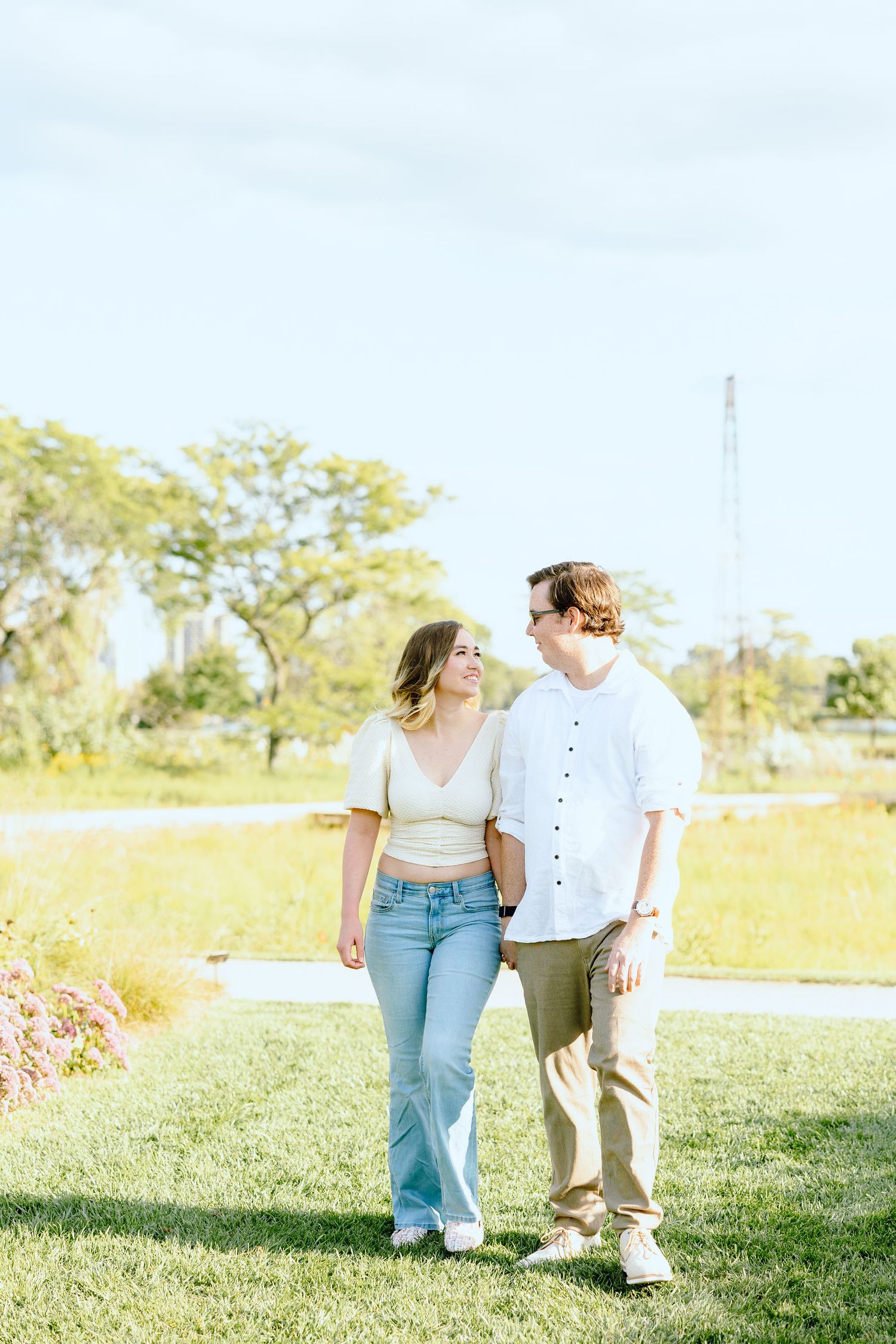 Engaged couple walking and holding hands at Belle Isle summer engagement session in Detroit, MI