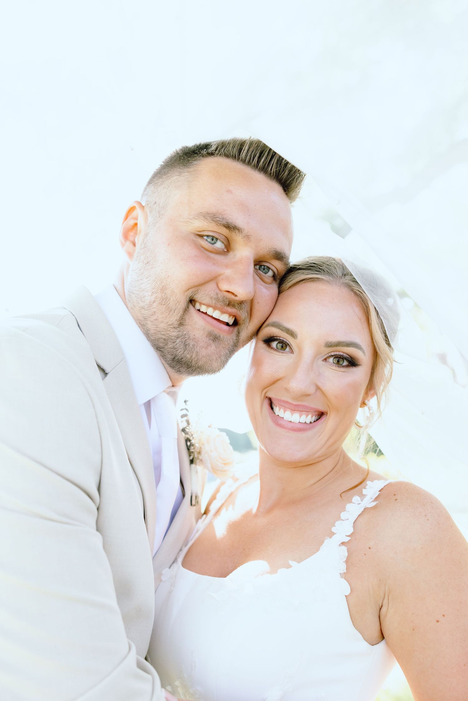 Married couple embracing under veil at Lapeer Country Club, Mi