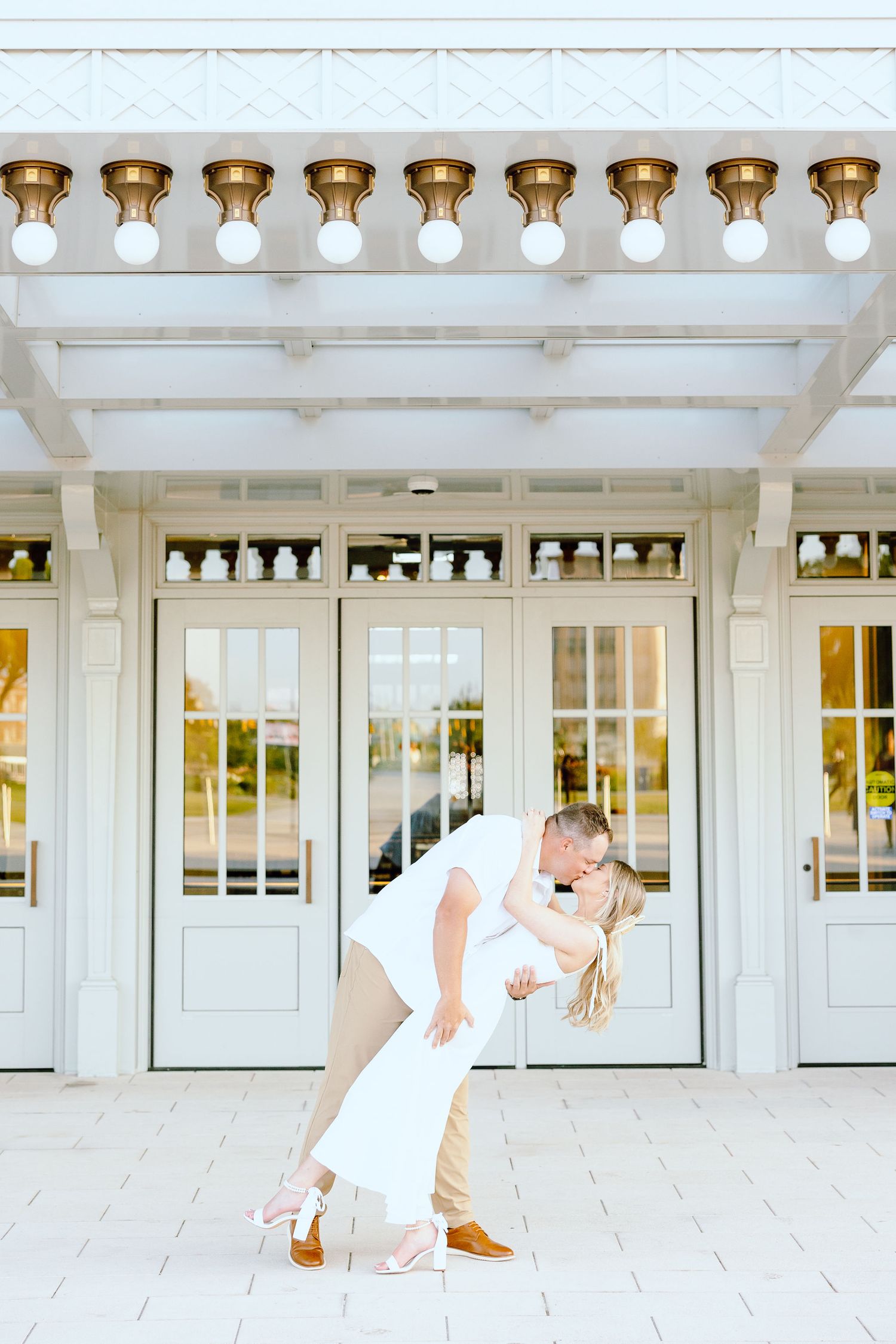 Engaged couple dipping and kissing at Michigan Central Station summer engagement session in Detroit, MI