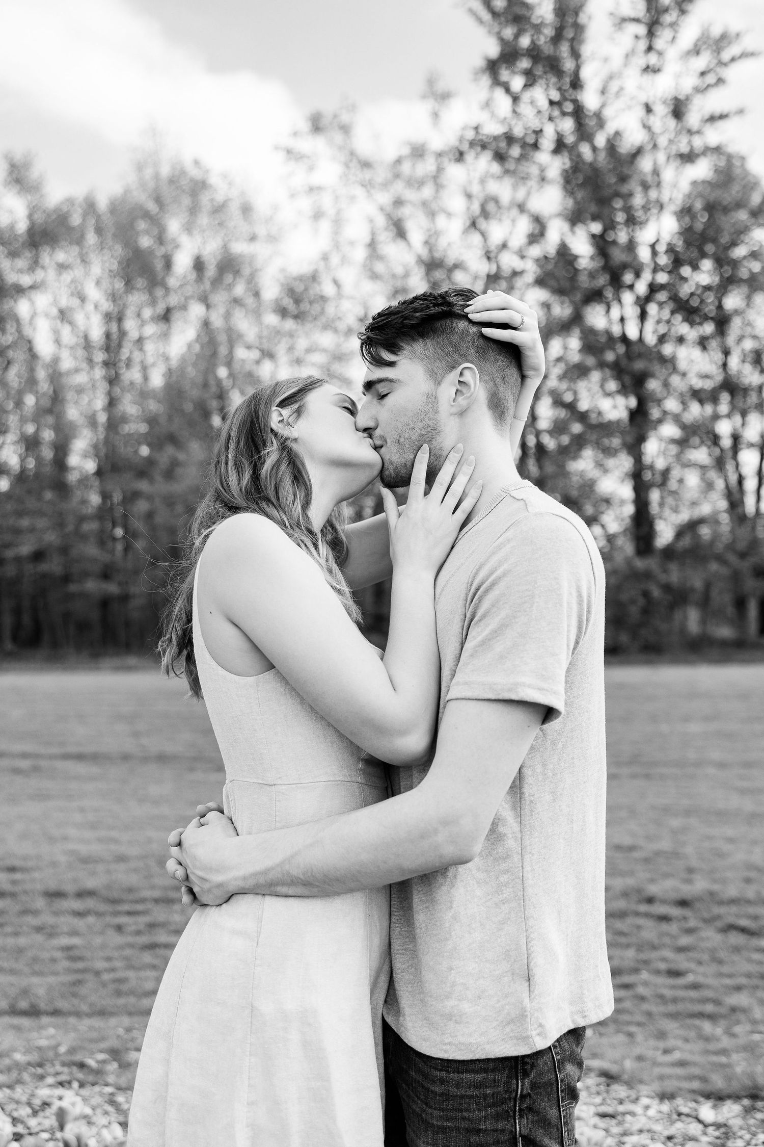 Engaged couple kissing at DeBuck's tulip field spring engagement session in Belleville, MI