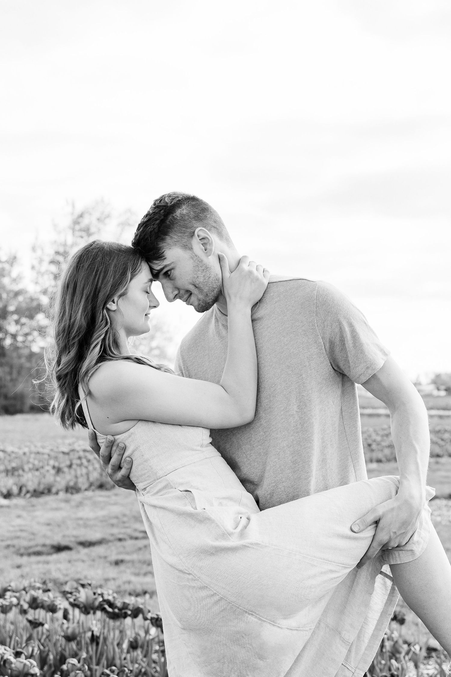 Engaged couple dipping at DeBuck's tulip field spring engagement session in Belleville, MI