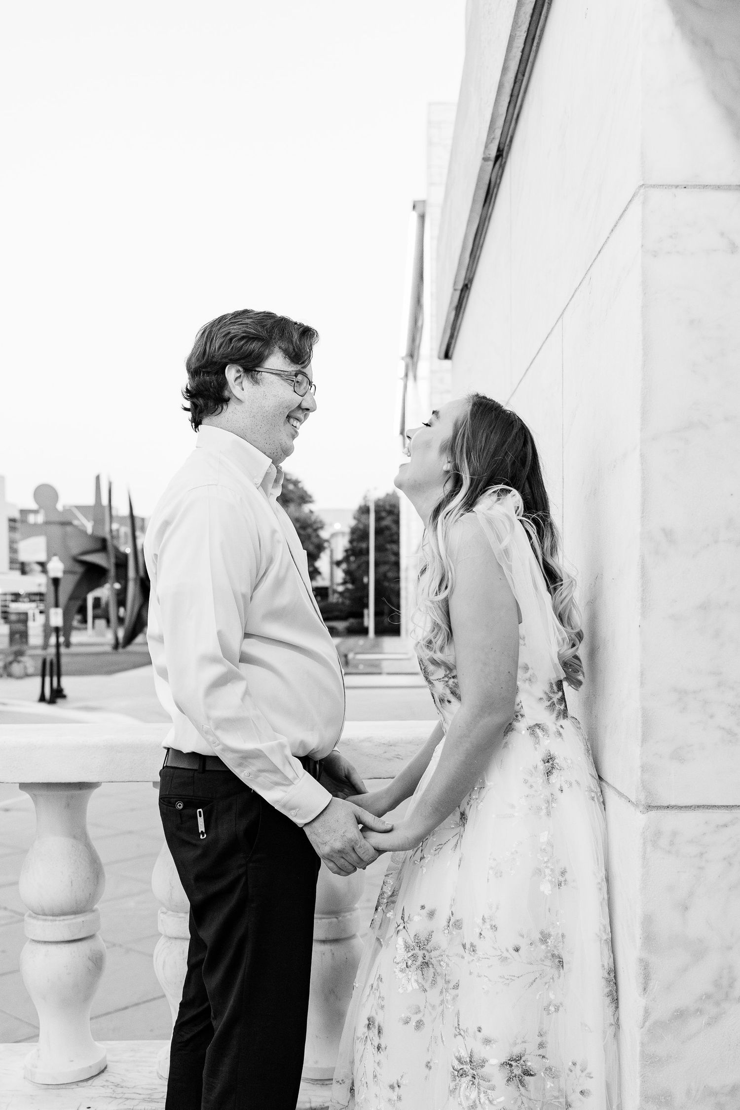Engaged couple leaning against wall at Belle Isle summer engagement session in Detroit, MI