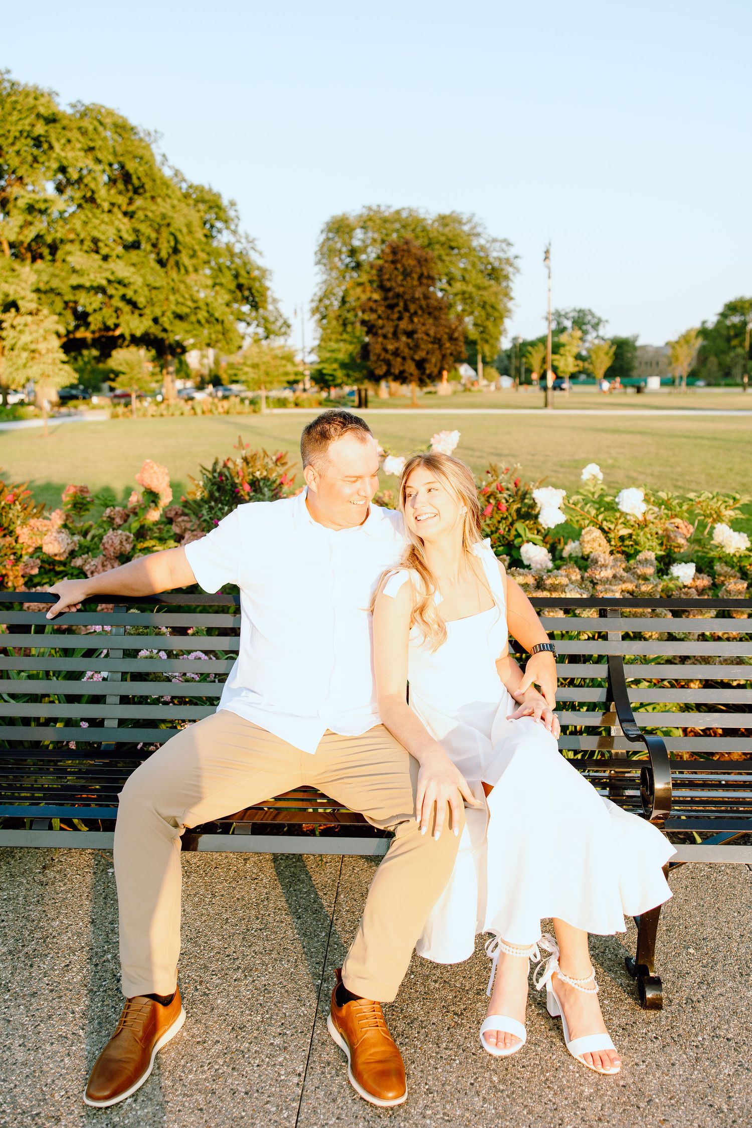 Engaged couple embracing on bench at Michigan Central Station in Detroit, MI