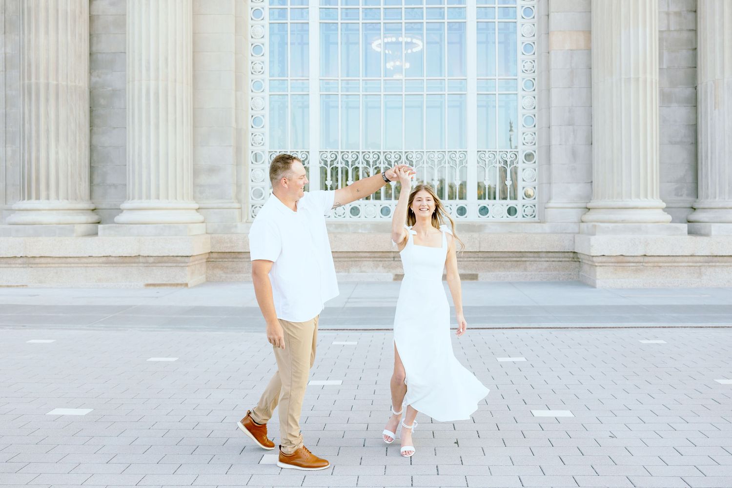 Engaged couple twirling at Michigan Central Station summer engagement session in Detroit, MI