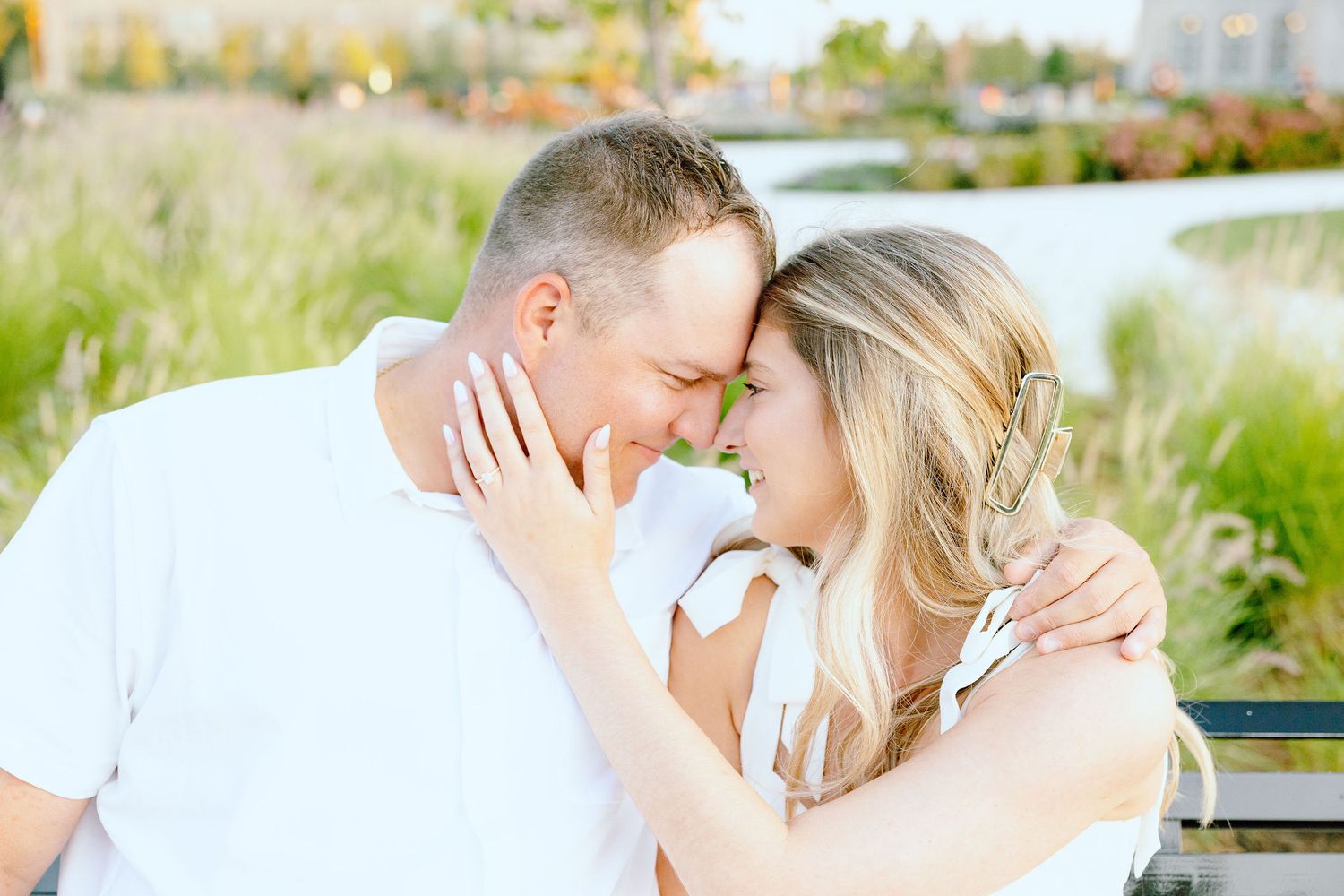 Engaged couple embracing on bench at Michigan Central Station in Detroit, MI