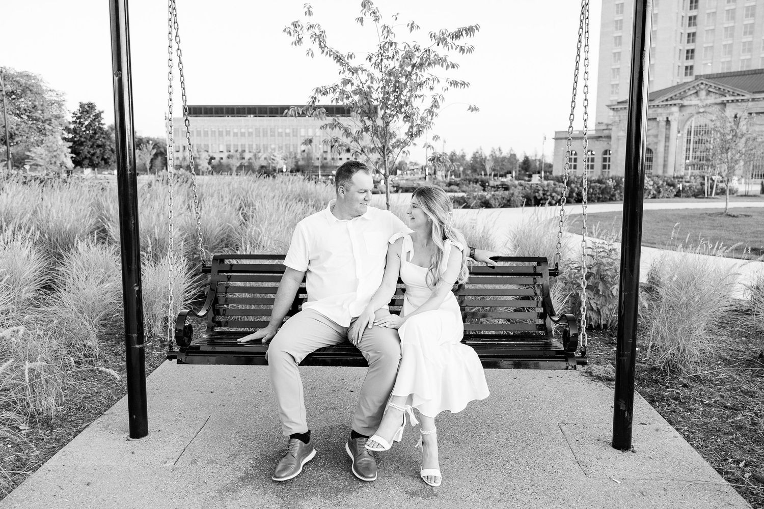 Engaged couple sitting on bench at Michigan Central Station in Detroit, MI