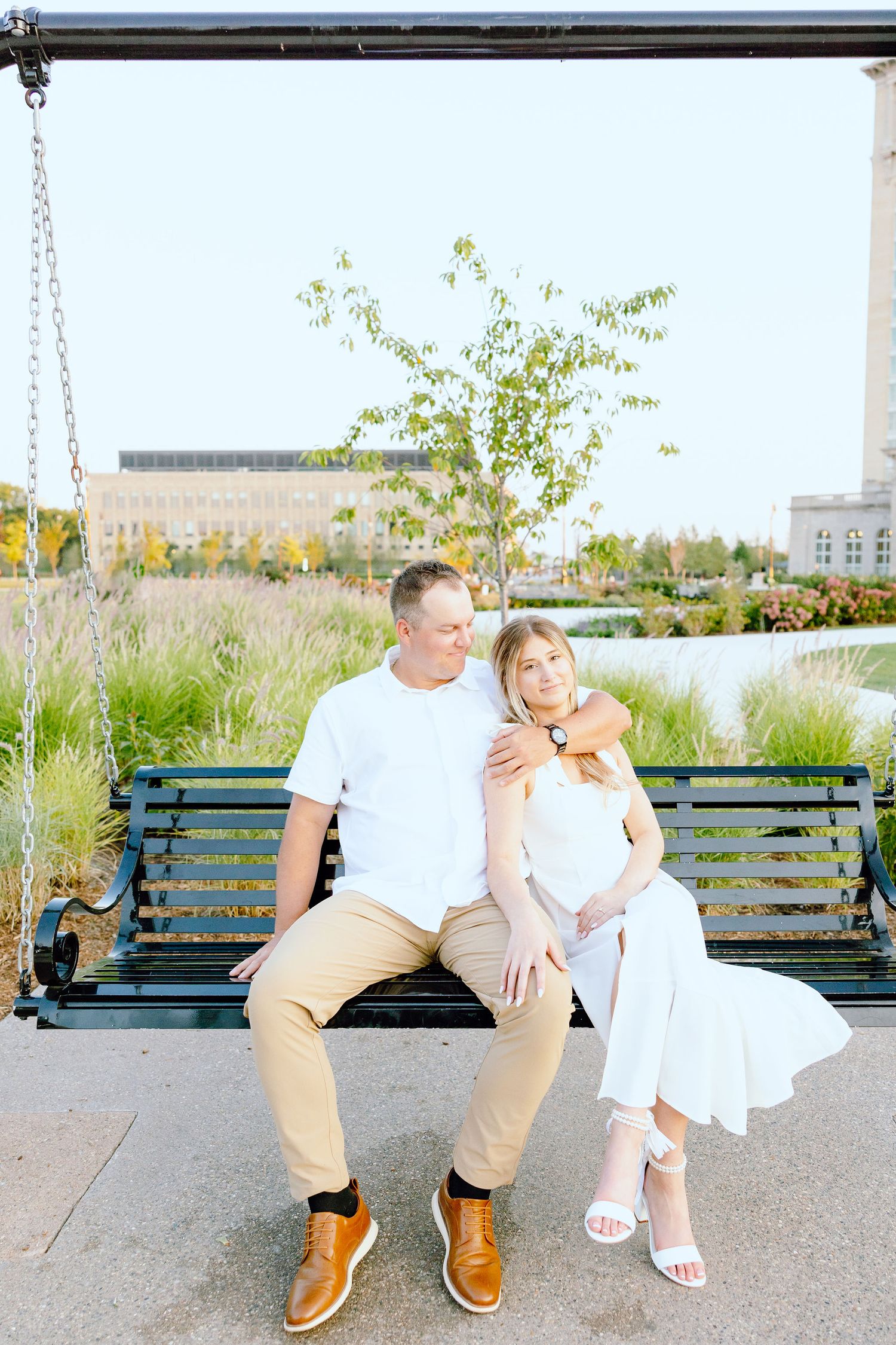 Engaged couple embracing on bench at Michigan Central Station in Detroit, MI