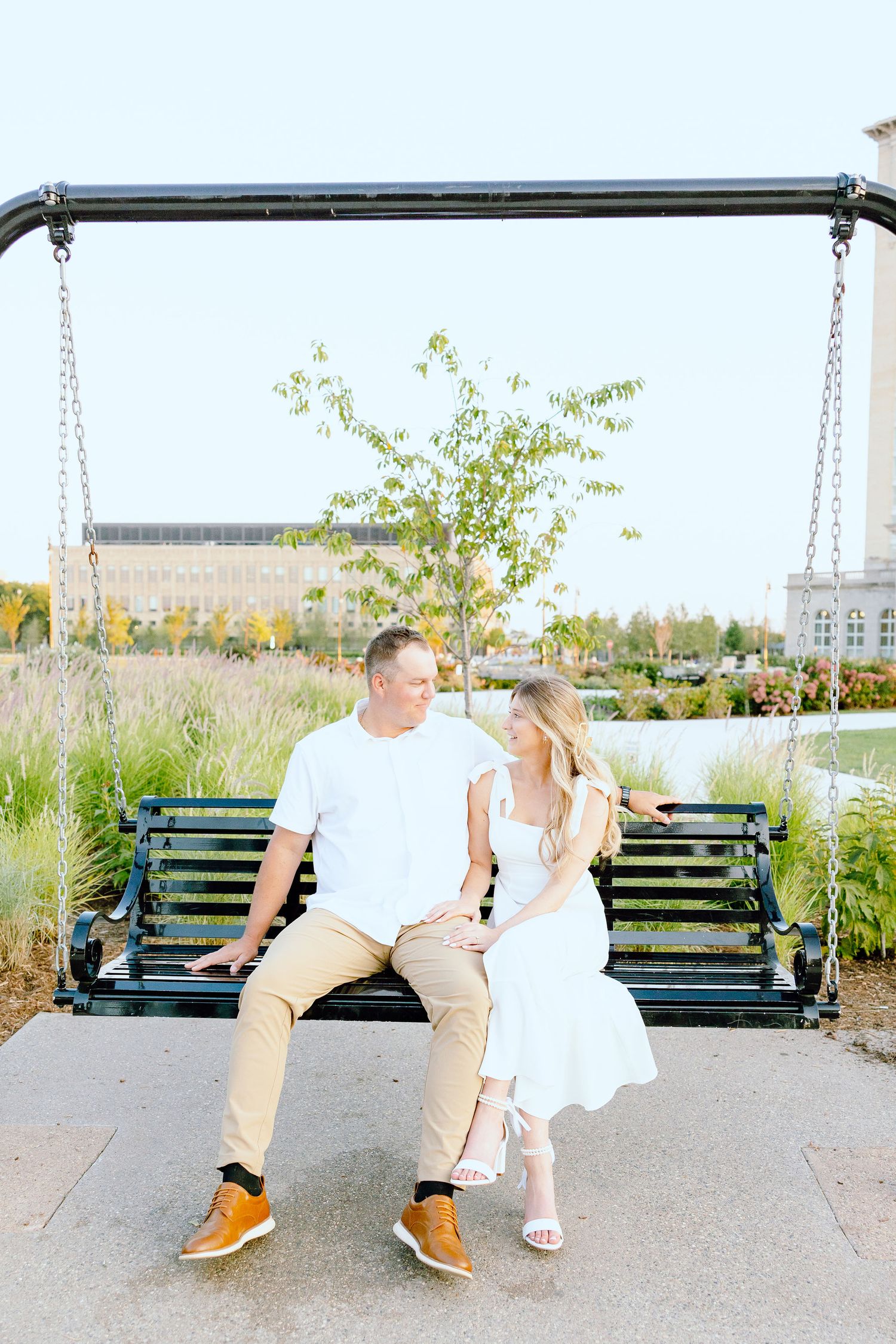 Engaged couple sitting on bench at Michigan Central Station in Detroit, MI