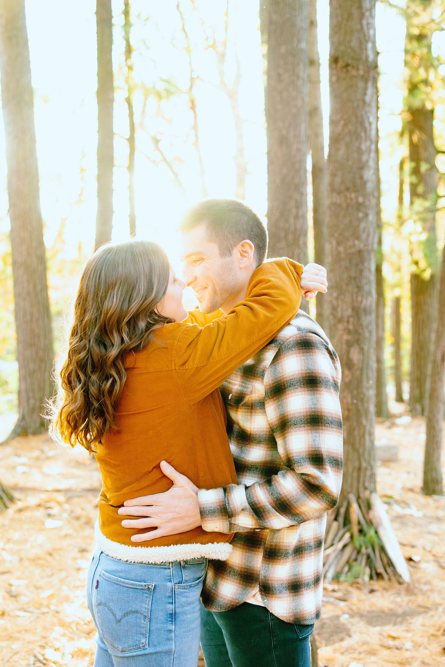 Engaged couple embracing in forest at Nichols Arboretum fall engagement session in Ann Arbor, MI