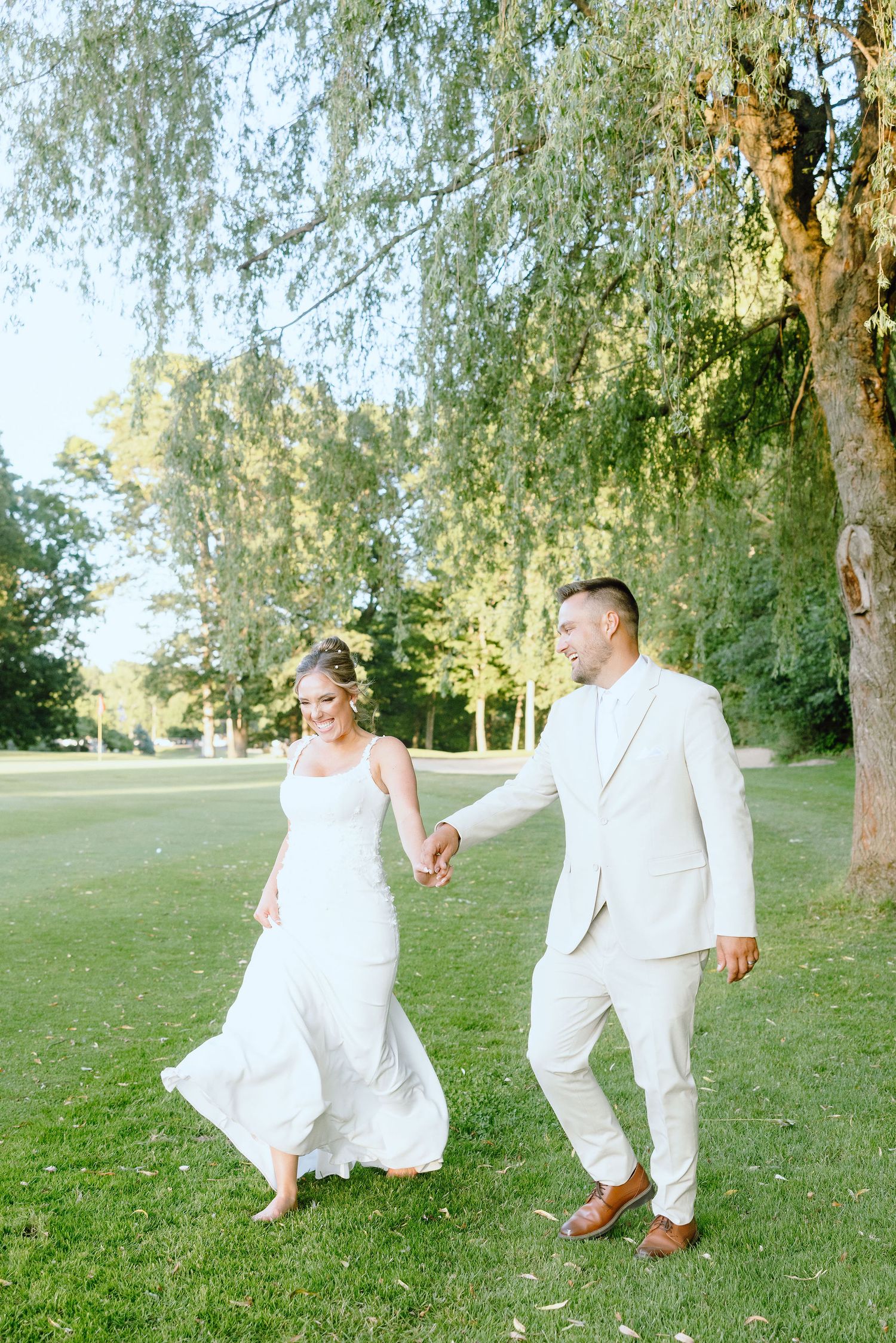 Married couple walking during golden hour at Lapeer Country Club wedding in Michigan