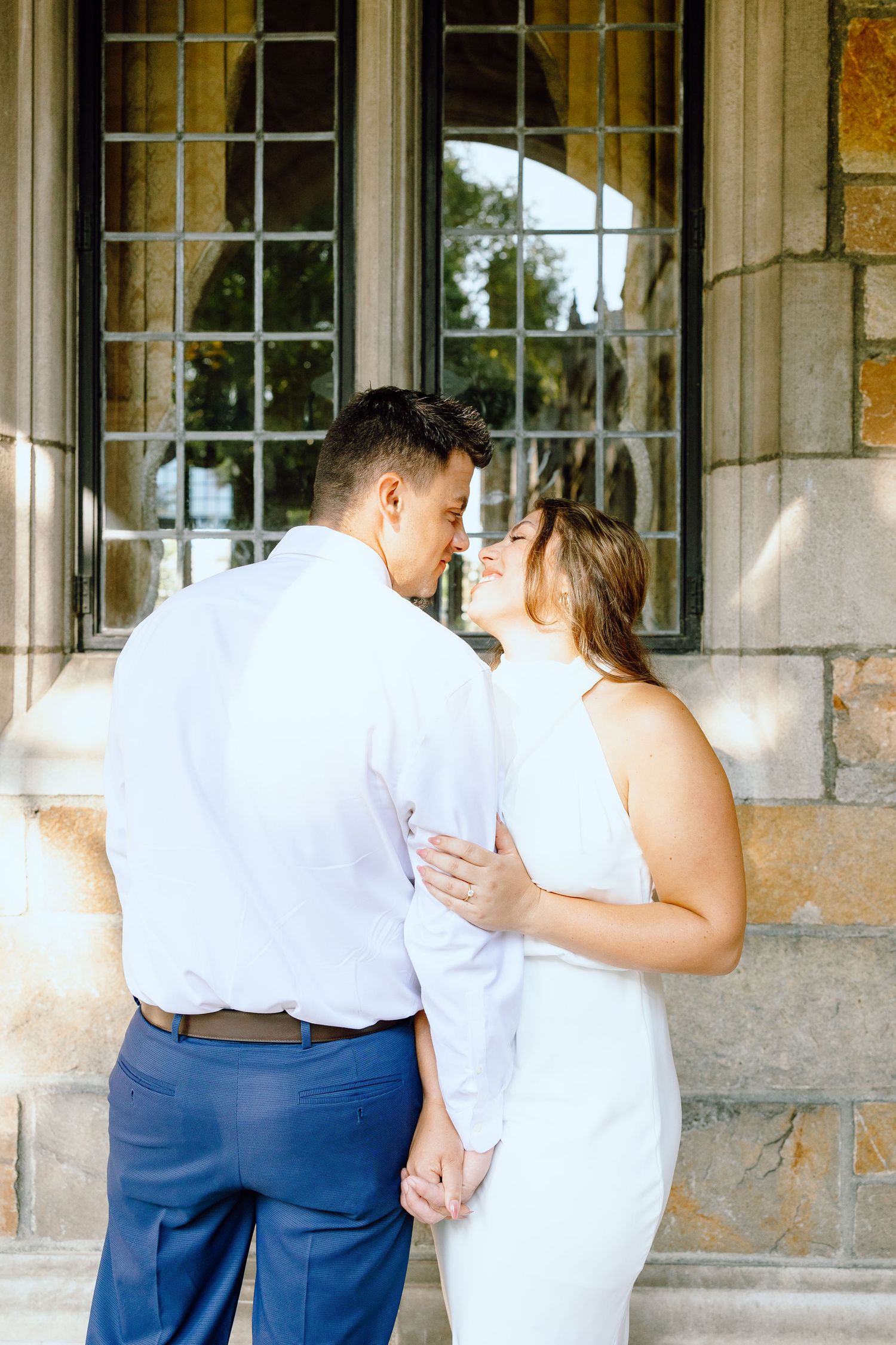 Engaged couple embracing at the University of Michigan Law Quad engagement session in Ann Arbor, MI