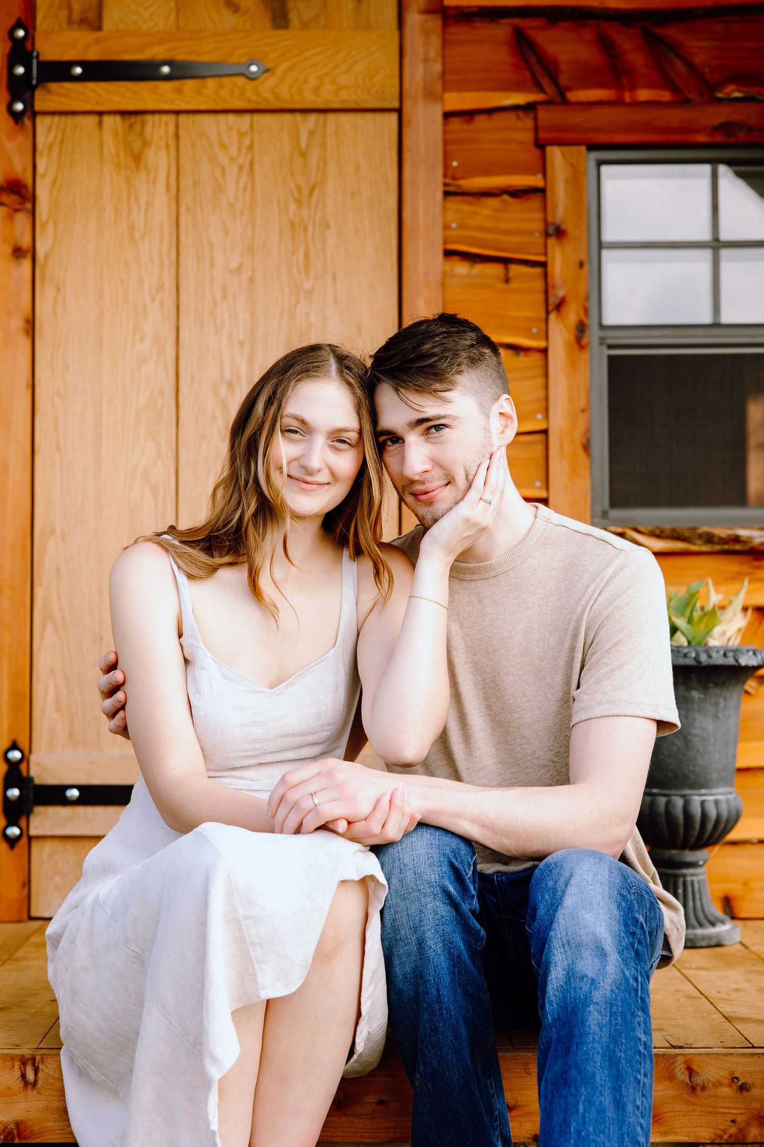 Engaged couple sitting on bench at DeBuck's tulip field spring engagement session in Belleville, MI