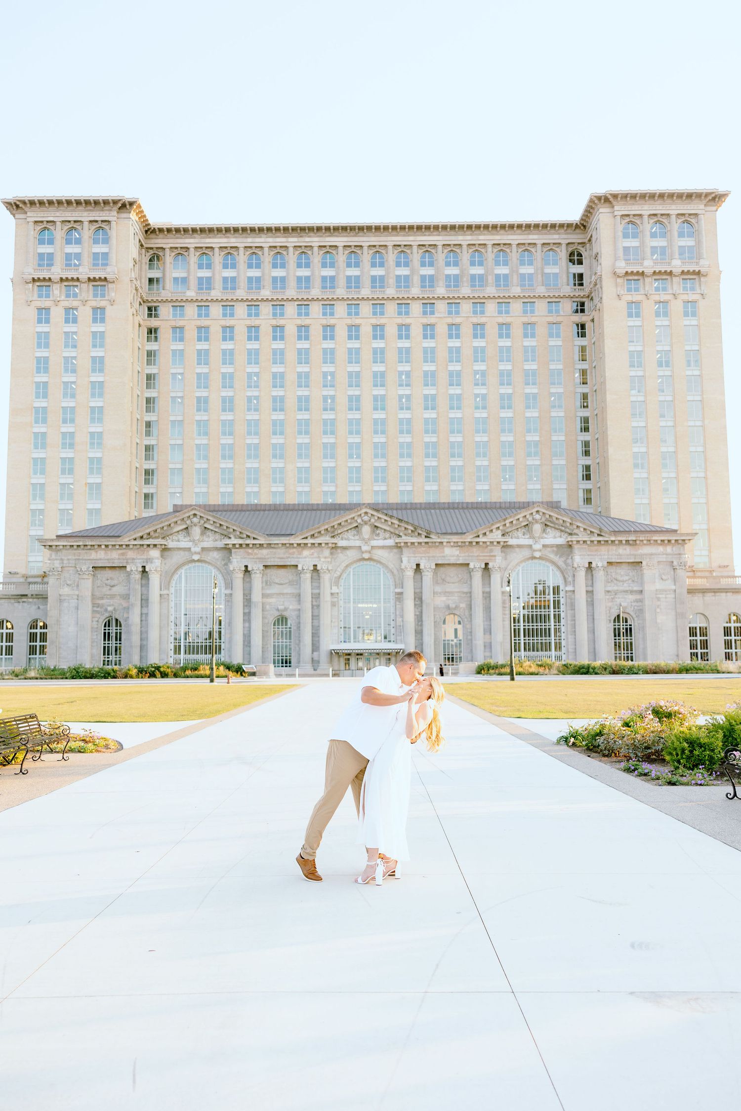 Engaged couple dipping and kissing at Michigan Central Station summer engagement session in Detroit, MI