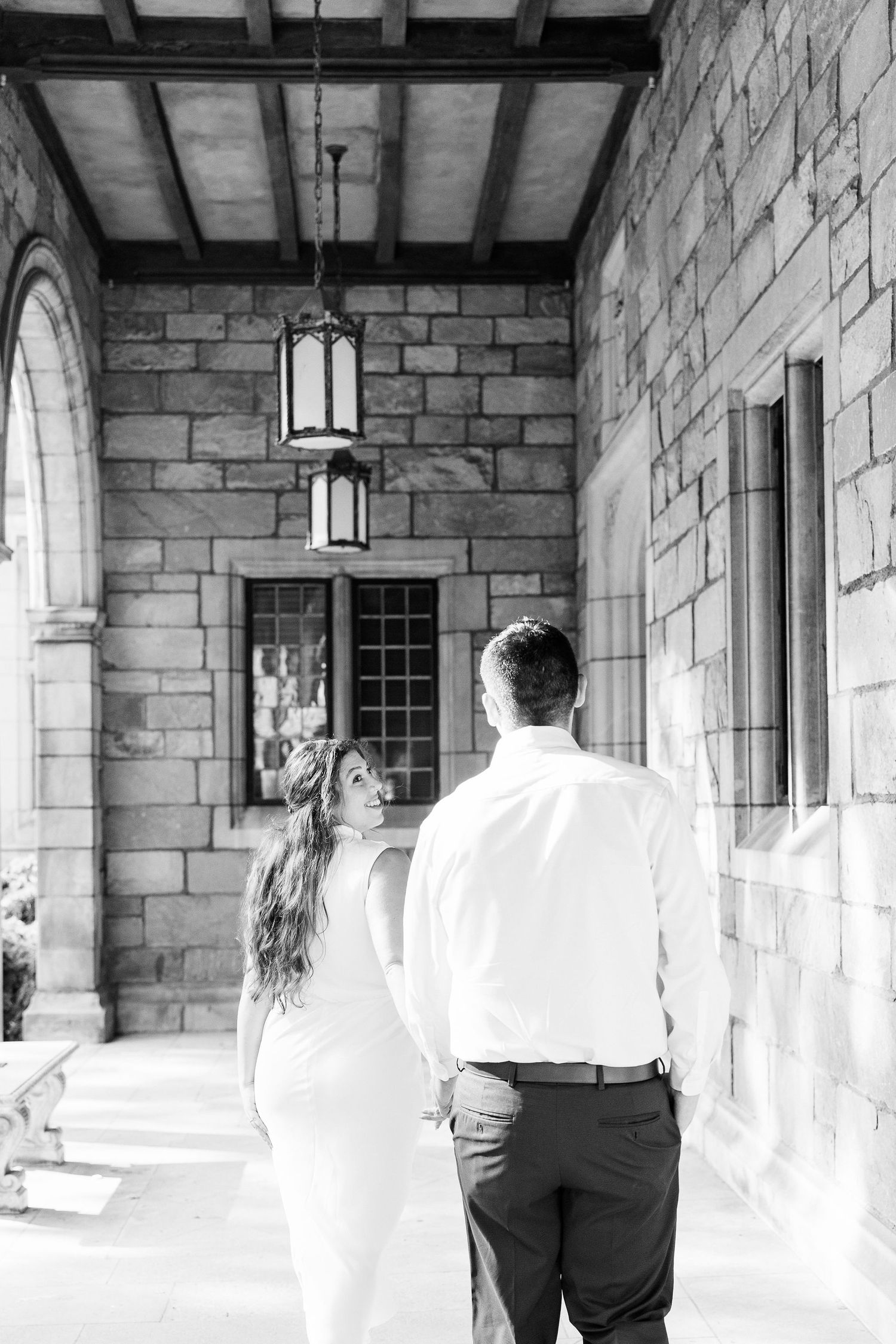 Engaged couple walking and holding hands at the UofM Law Quad engagement session in Ann Arbor, MI