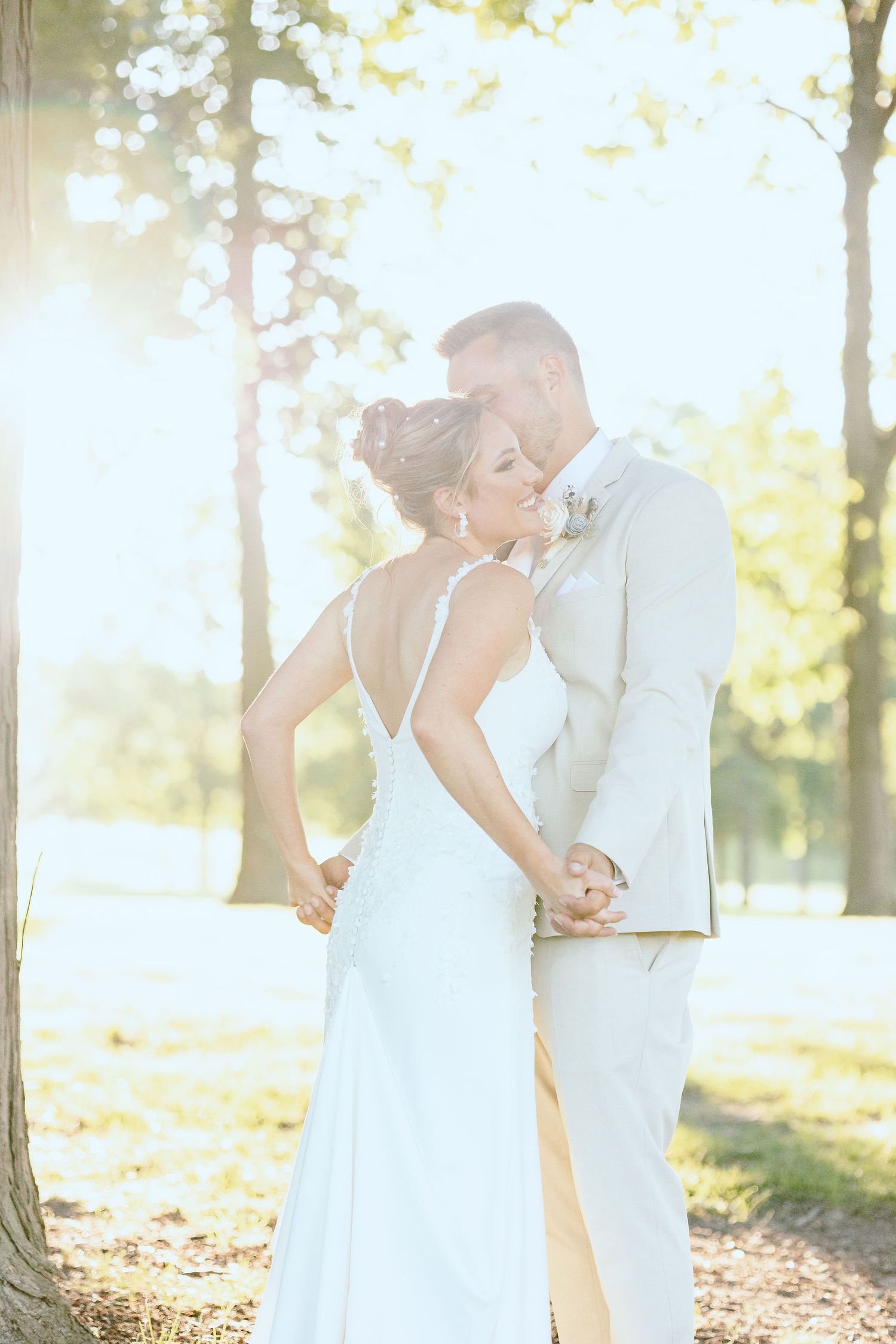 Married couple embracing during golden hour at Lapeer Country Club forest wedding in Michigan