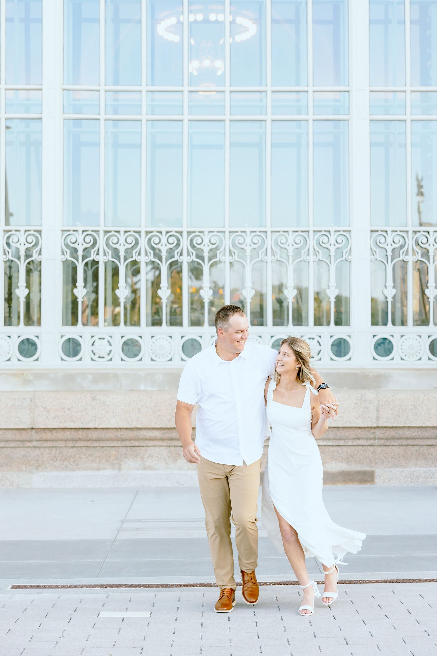 Engaged couple walking and holding hands at Michigan Central Station summer engagement session in Detroit, MI