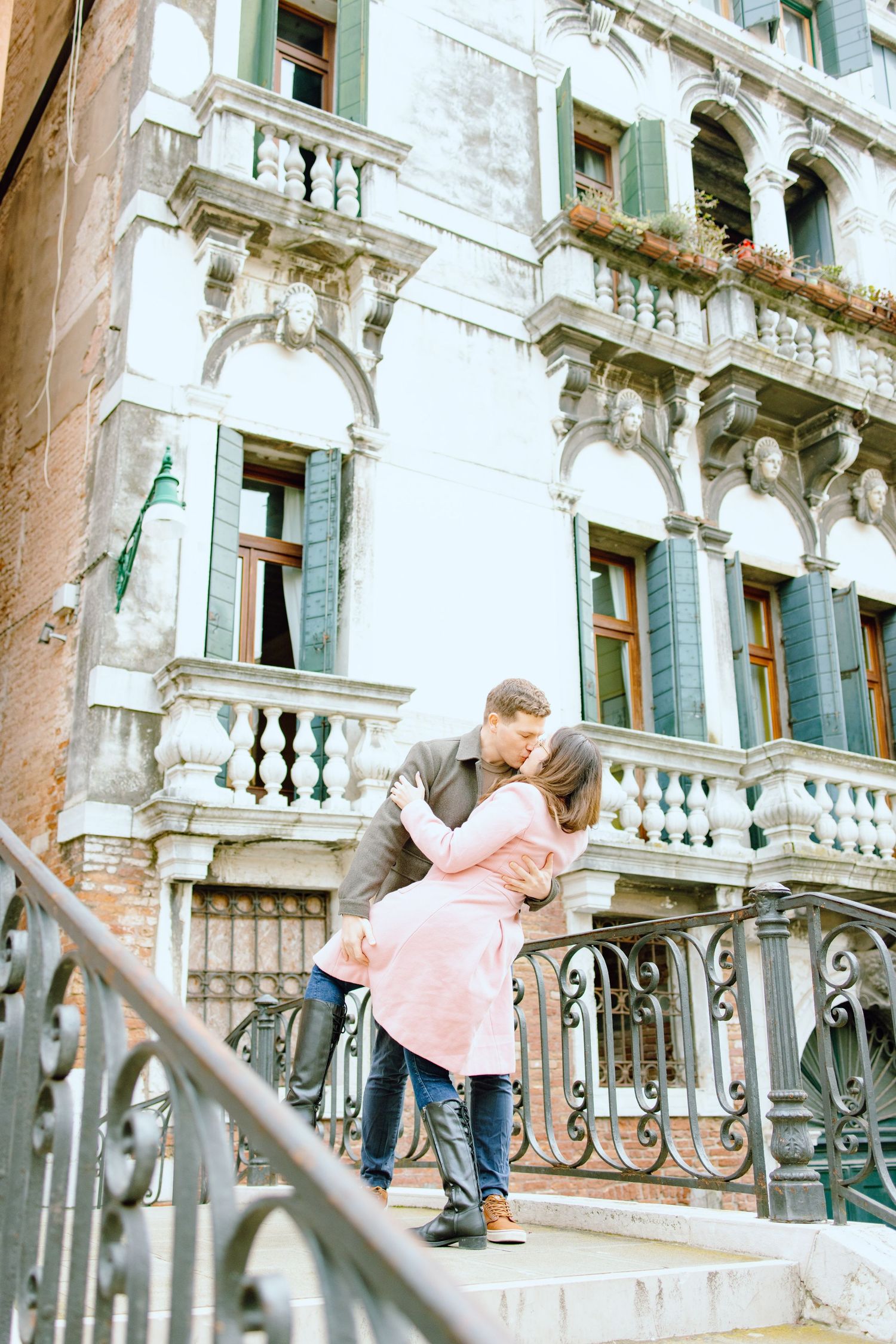 Engaged couple dipping and kissing on bridge in Venice, Italy
