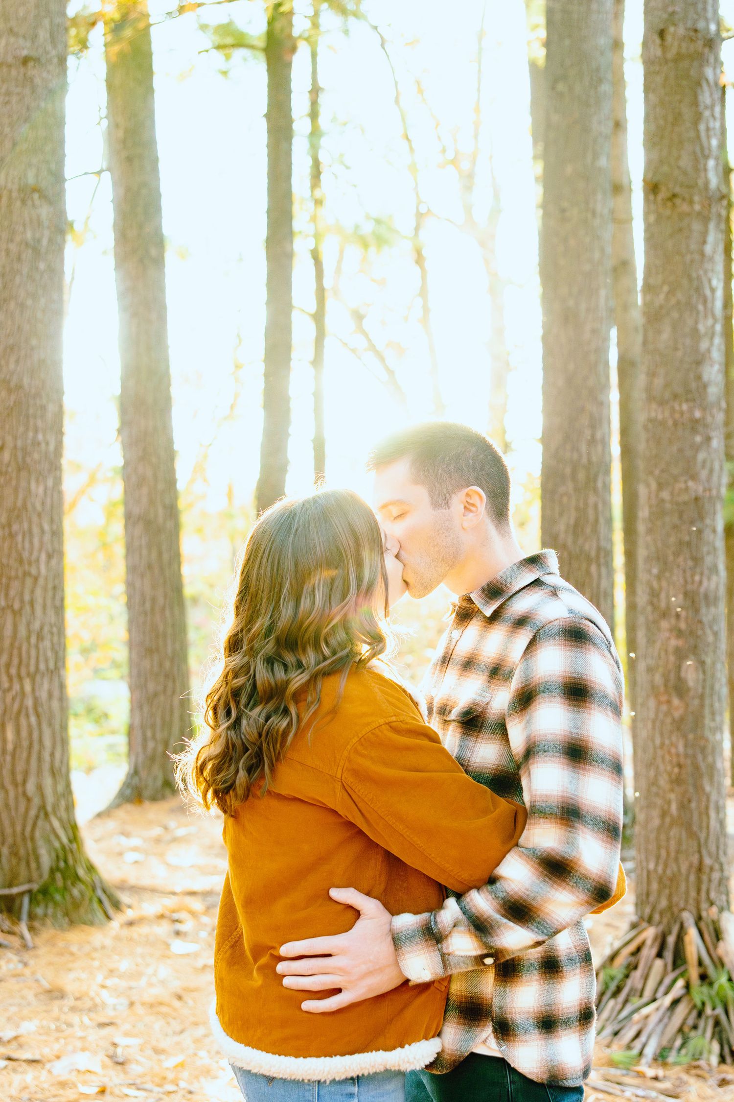 Engaged couple embracing in forest at Nichols Arboretum fall engagement session in Ann Arbor, MI