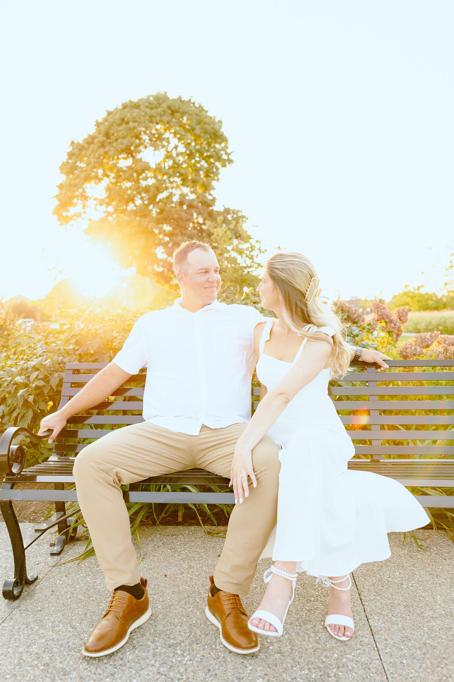 Engaged couple embracing on bench at Michigan Central Station in Detroit, MI