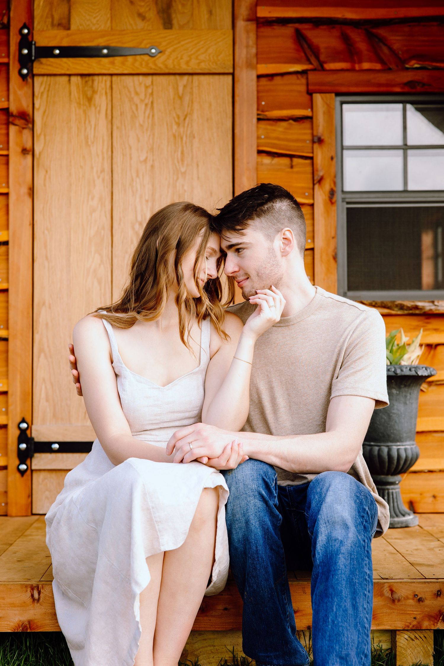 Engaged couple sitting on bench at DeBuck's tulip field spring engagement session in Belleville, MI